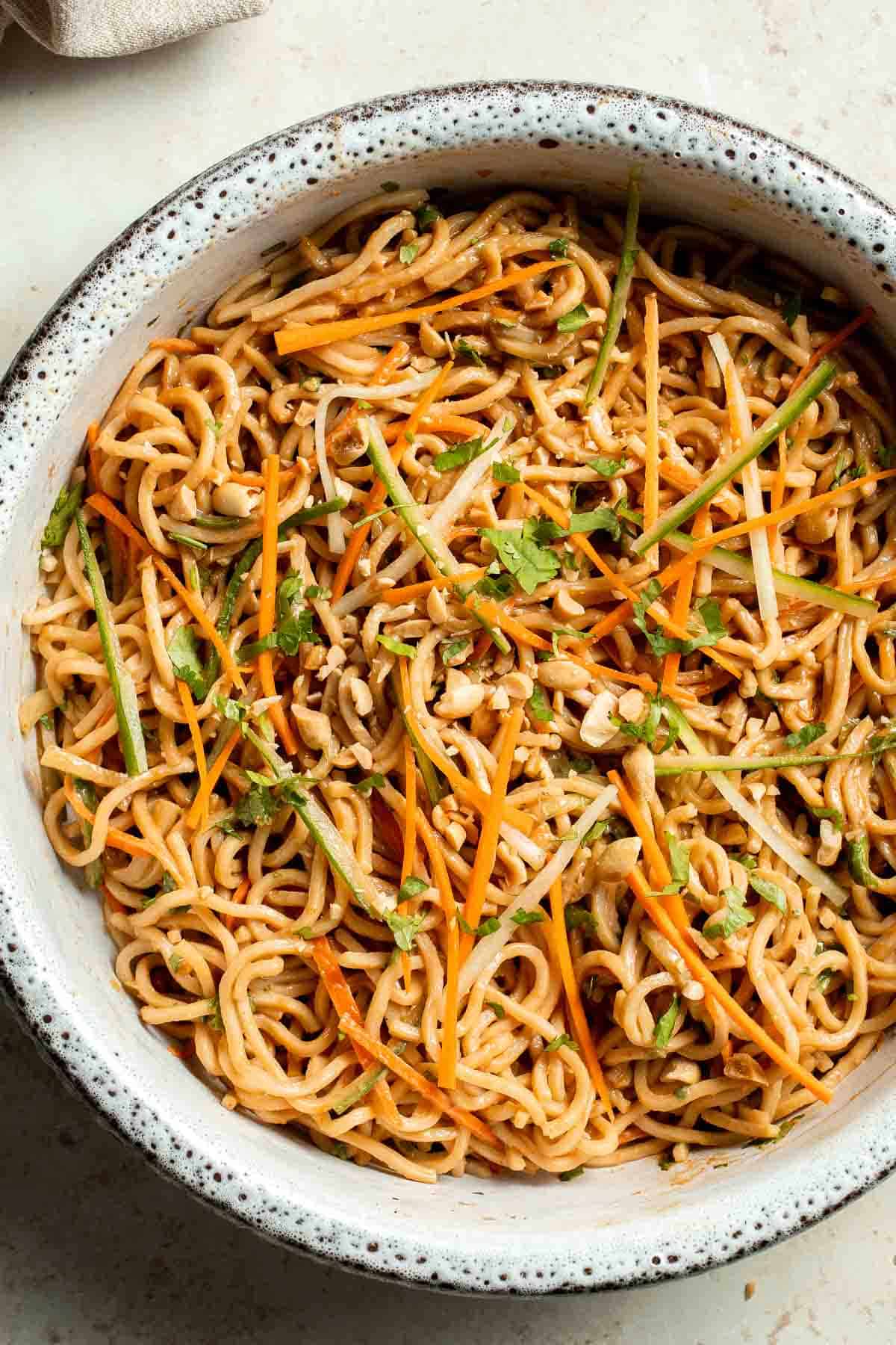 A bowl of Asian-style noodles mixed with julienned carrots, cucumber, bean sprouts, chopped peanuts, and fresh cilantro—perfect for lunch without sandwiches and great as a beach picnic food.