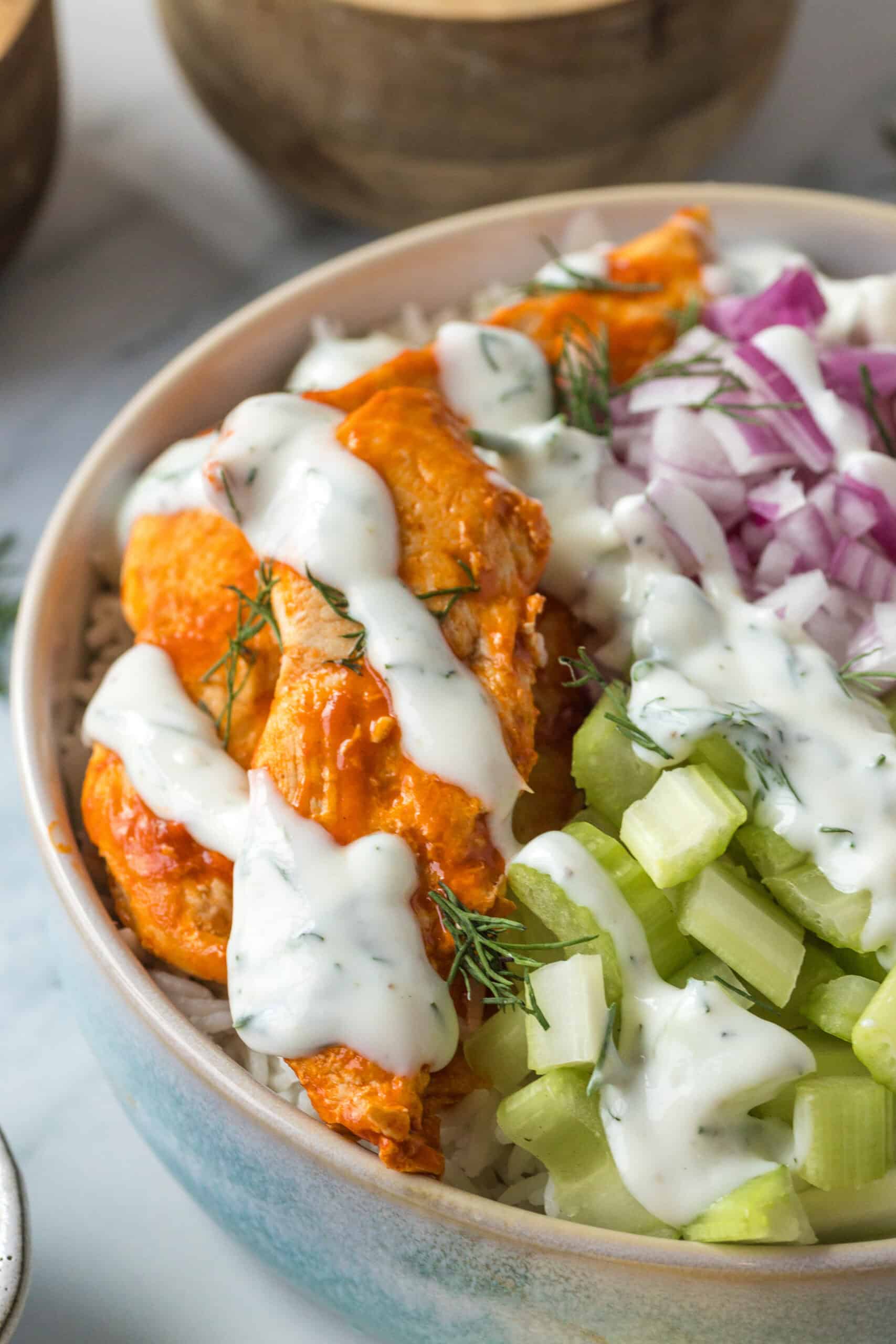 Close-up of buffalo chicken bowl drizzled with ranch dressing.