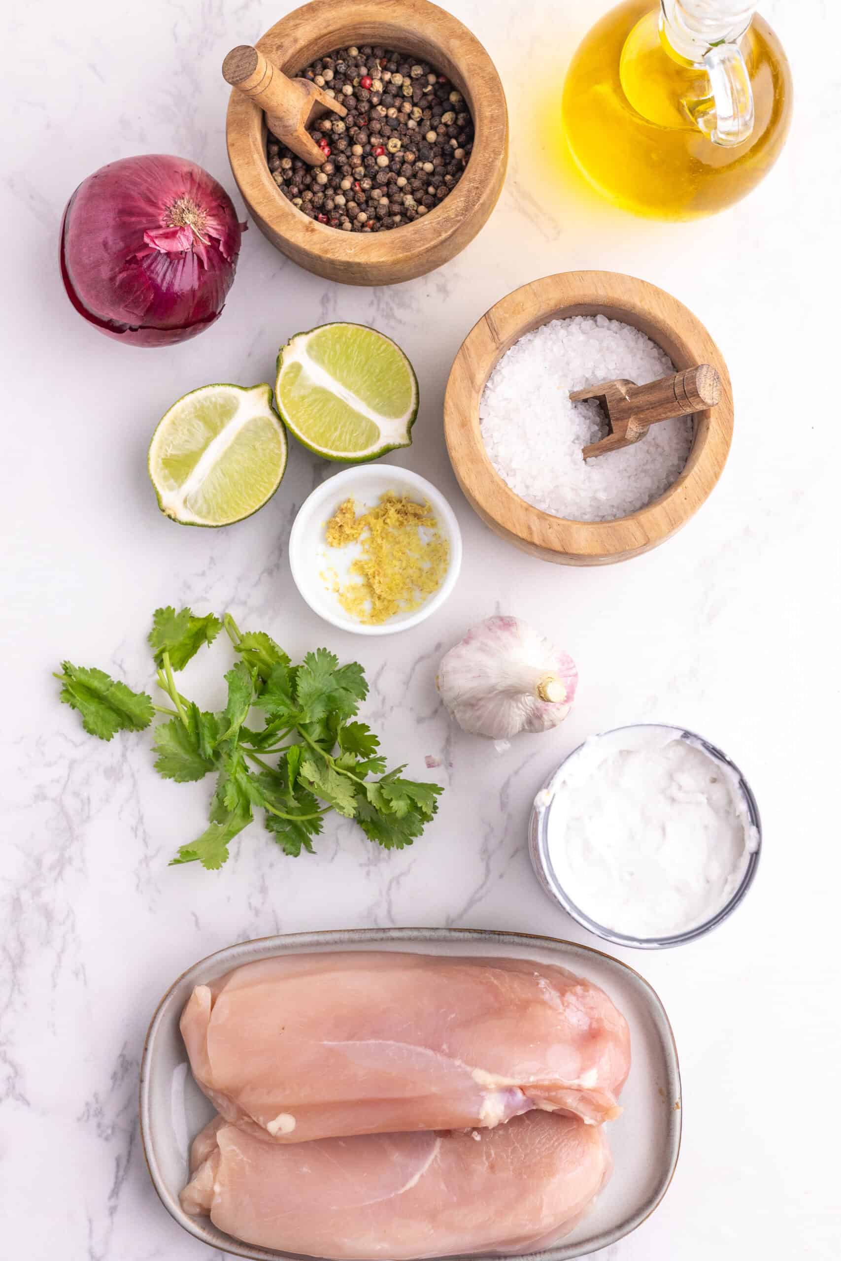 Chicken breasts, coconut milk, red onion, garlic, ginger, lime, cilantro, olive oil, salt, and pepper.