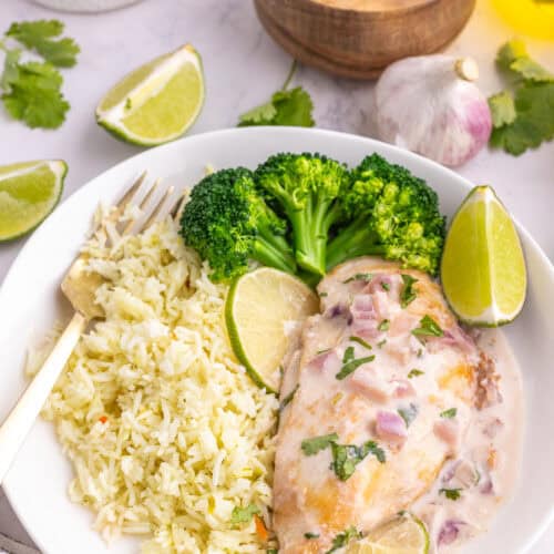 Coconut lime chicken served with rice, broccoli, lime, and cilantro.