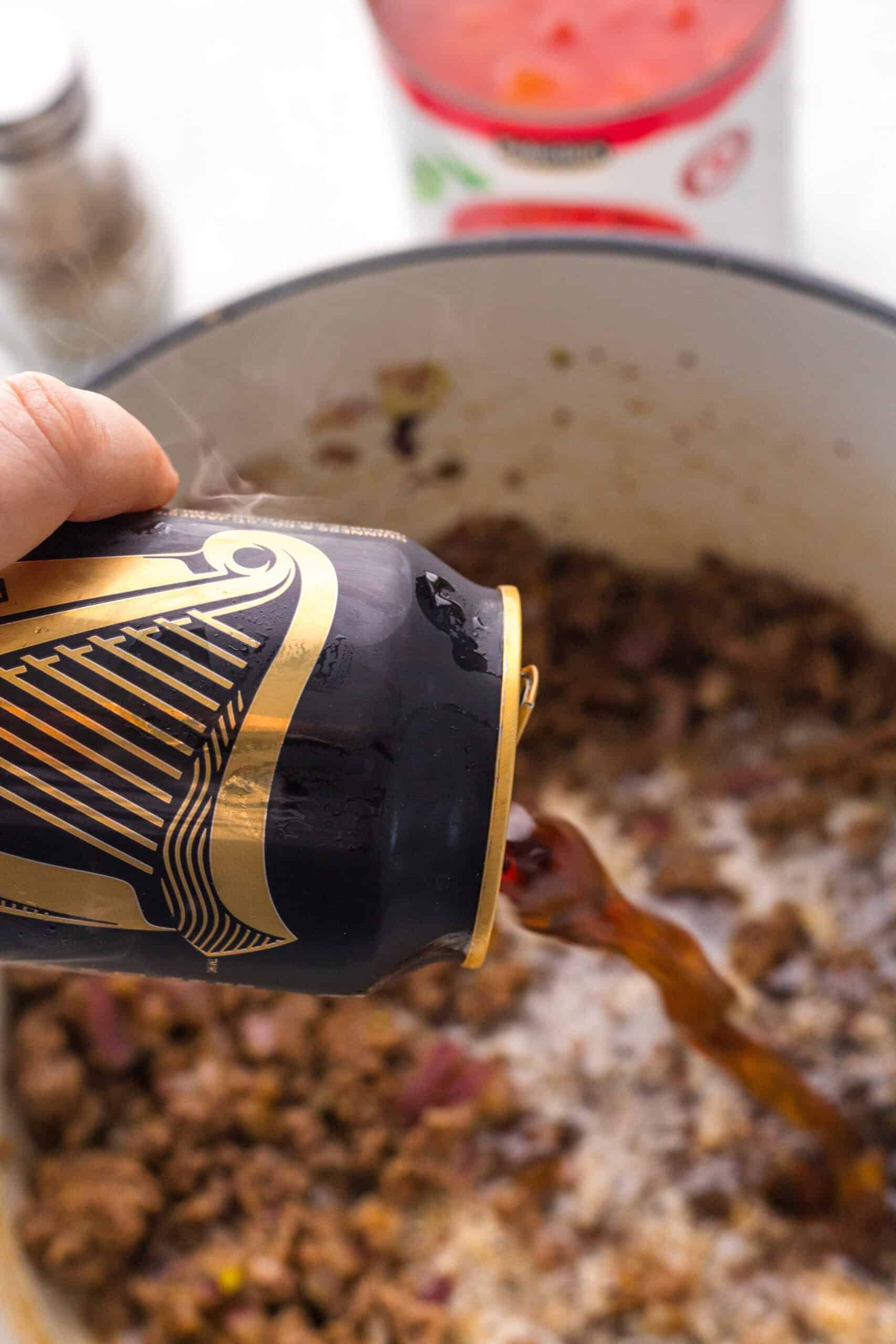 Guinness Draught being poured into browned beef and onion.