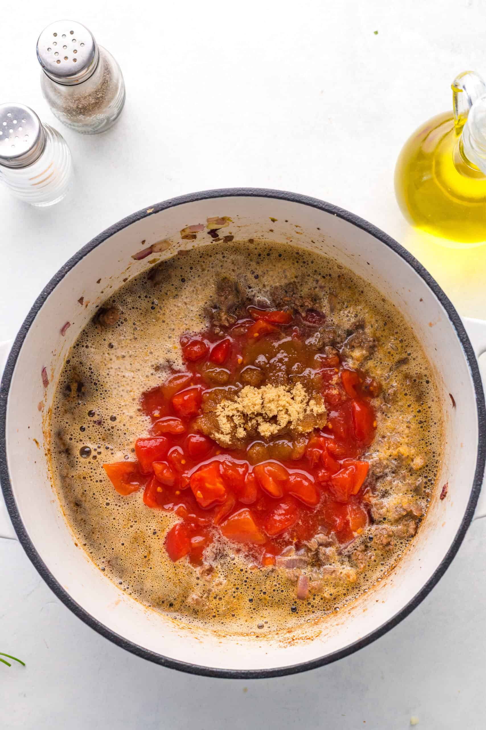 Diced tomatoes and brown sugar added to beef and Guinness in a pot.