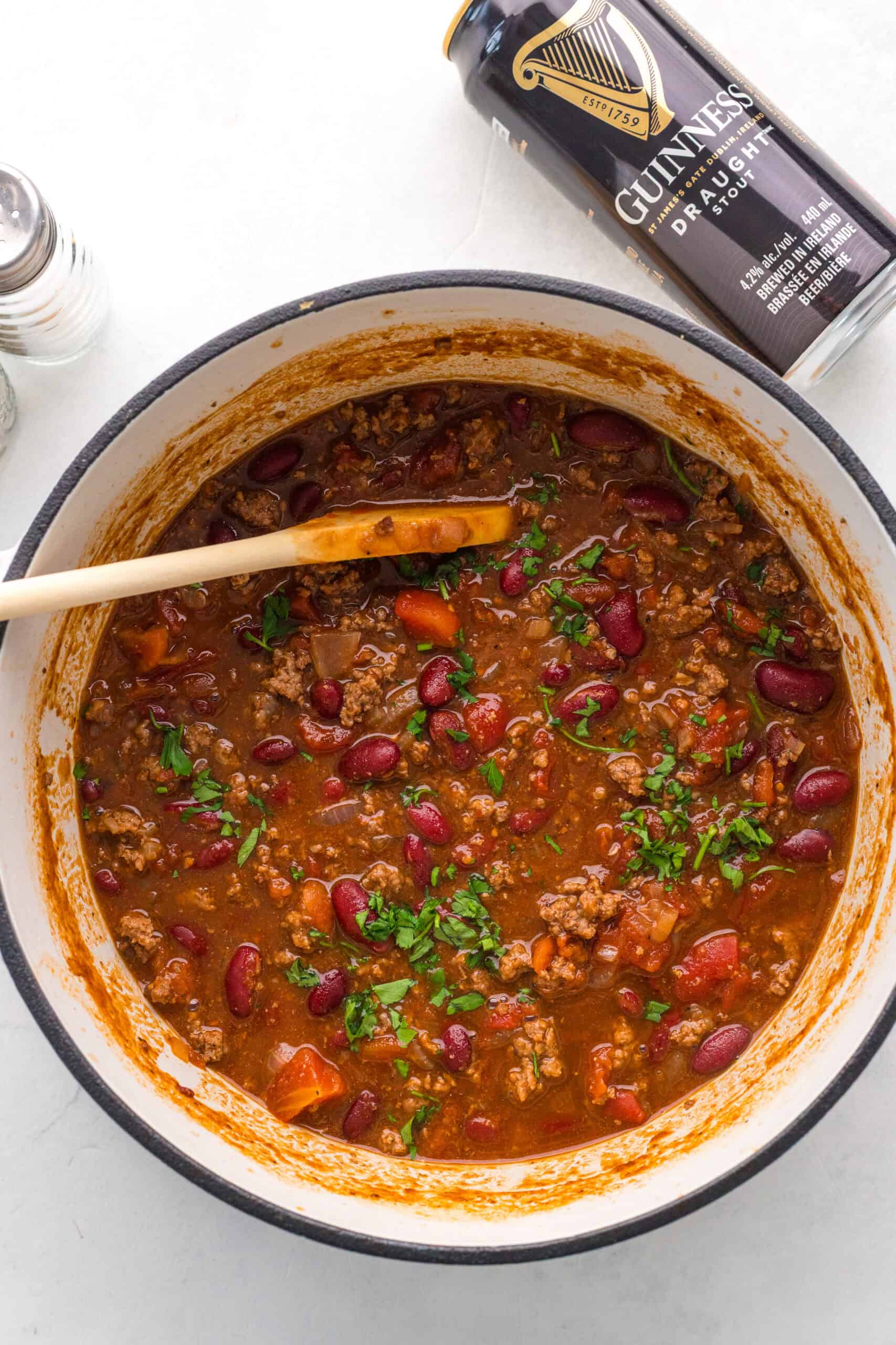 Thick Guinness chili simmered in a pot and garnished with parsley.