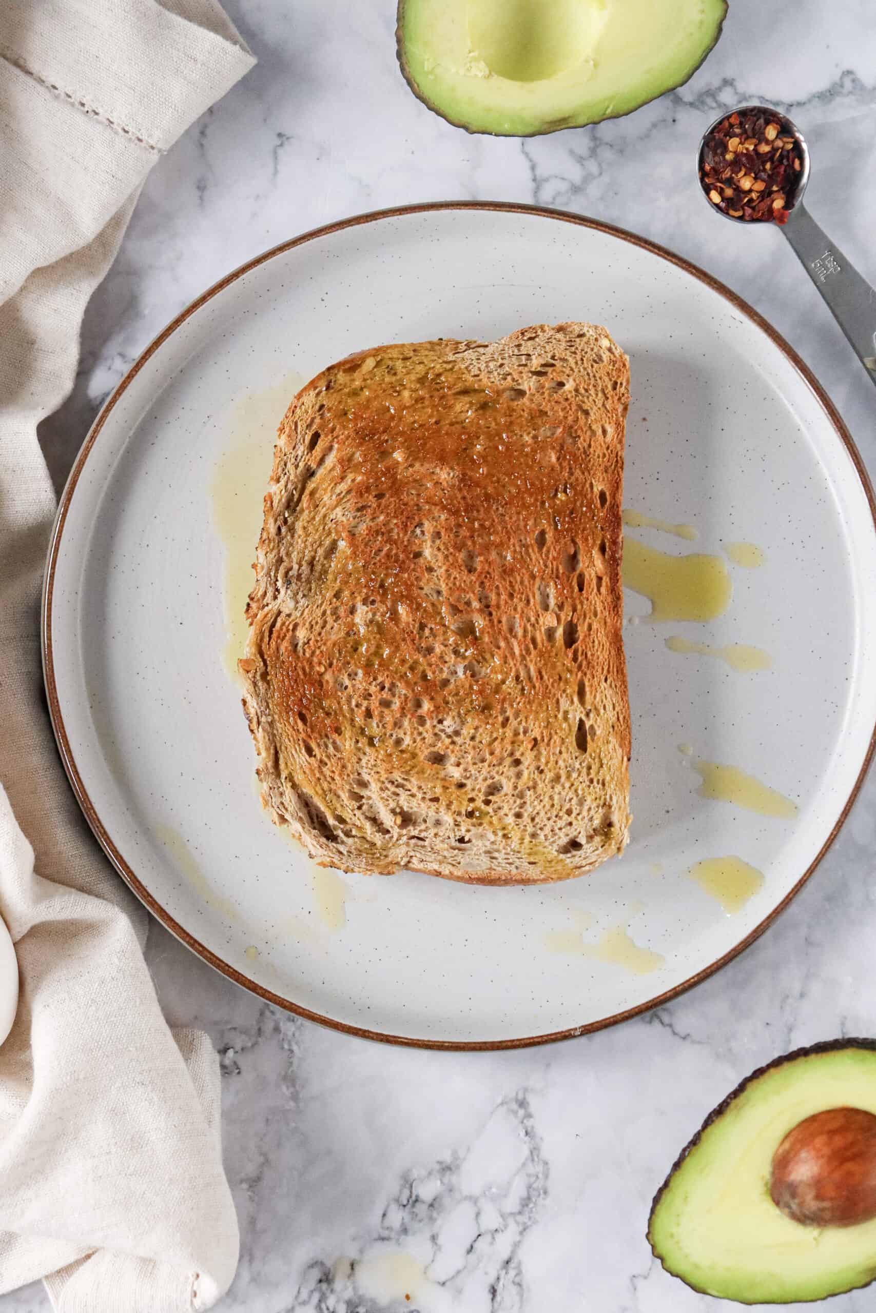 Golden toast drizzled with olive oil on a plate.