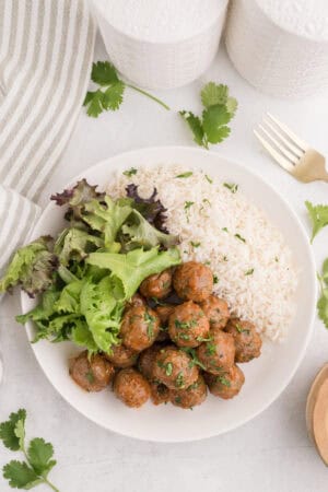 Sriracha meatballs served with rice and greens.