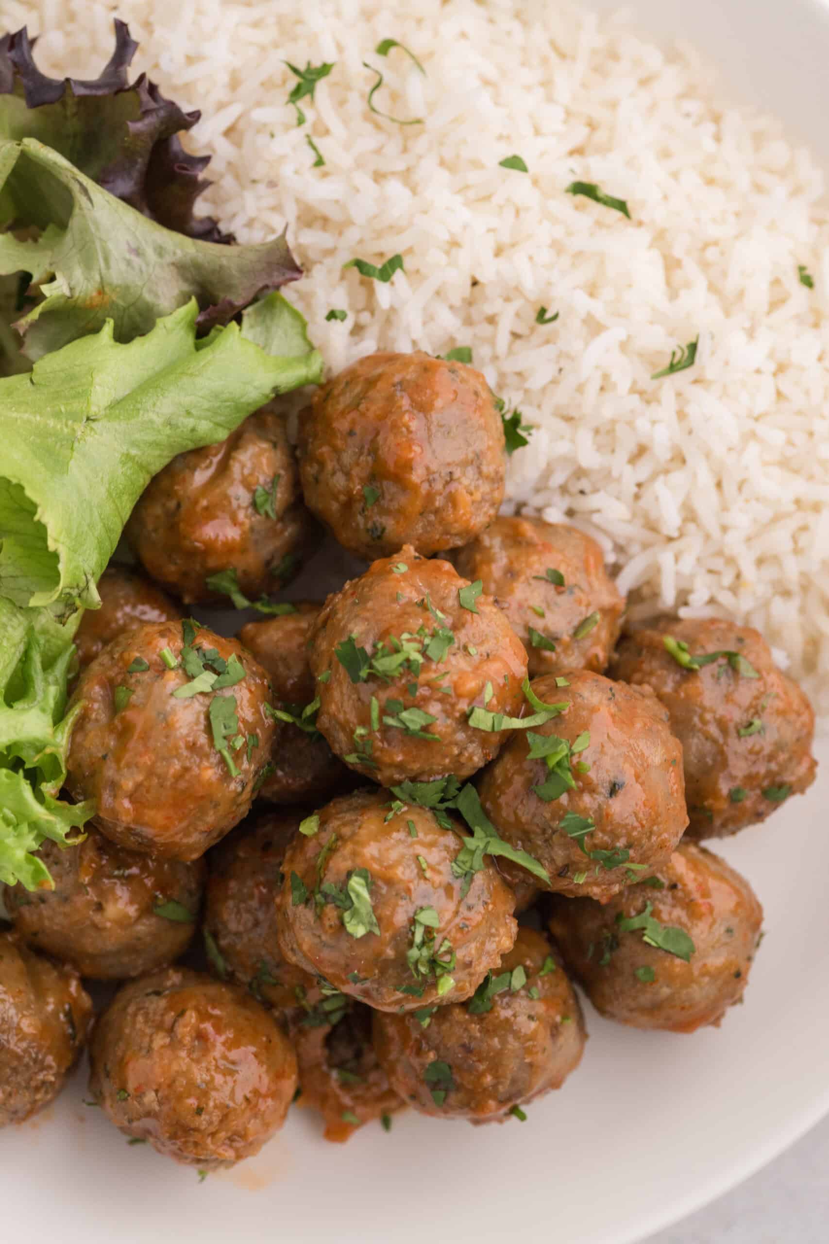 Close up of saucy sriracha meatballs served with rice.