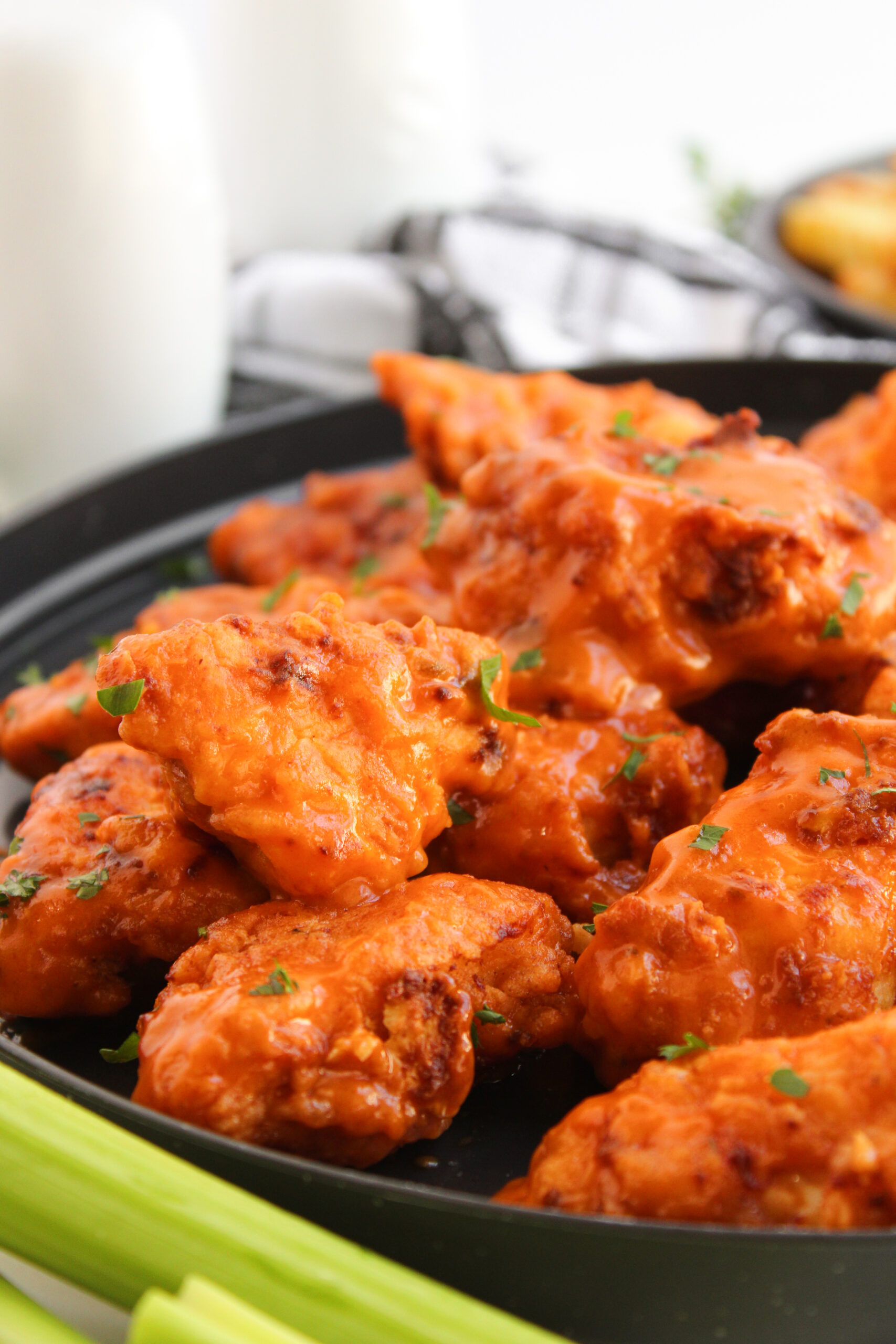 Crispy buffalo boneless wings coated in orange sauce and garnished with parsley.