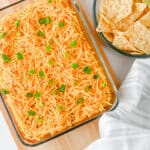 High protein nacho dip topped with cheddar cheese and green onions, served with tortilla chips.