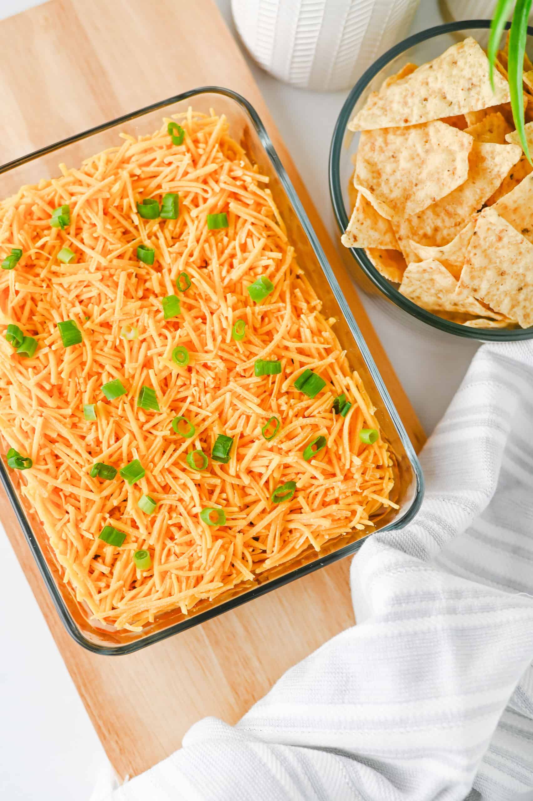 High protein nacho dip topped with cheddar cheese and green onions, served with tortilla chips.