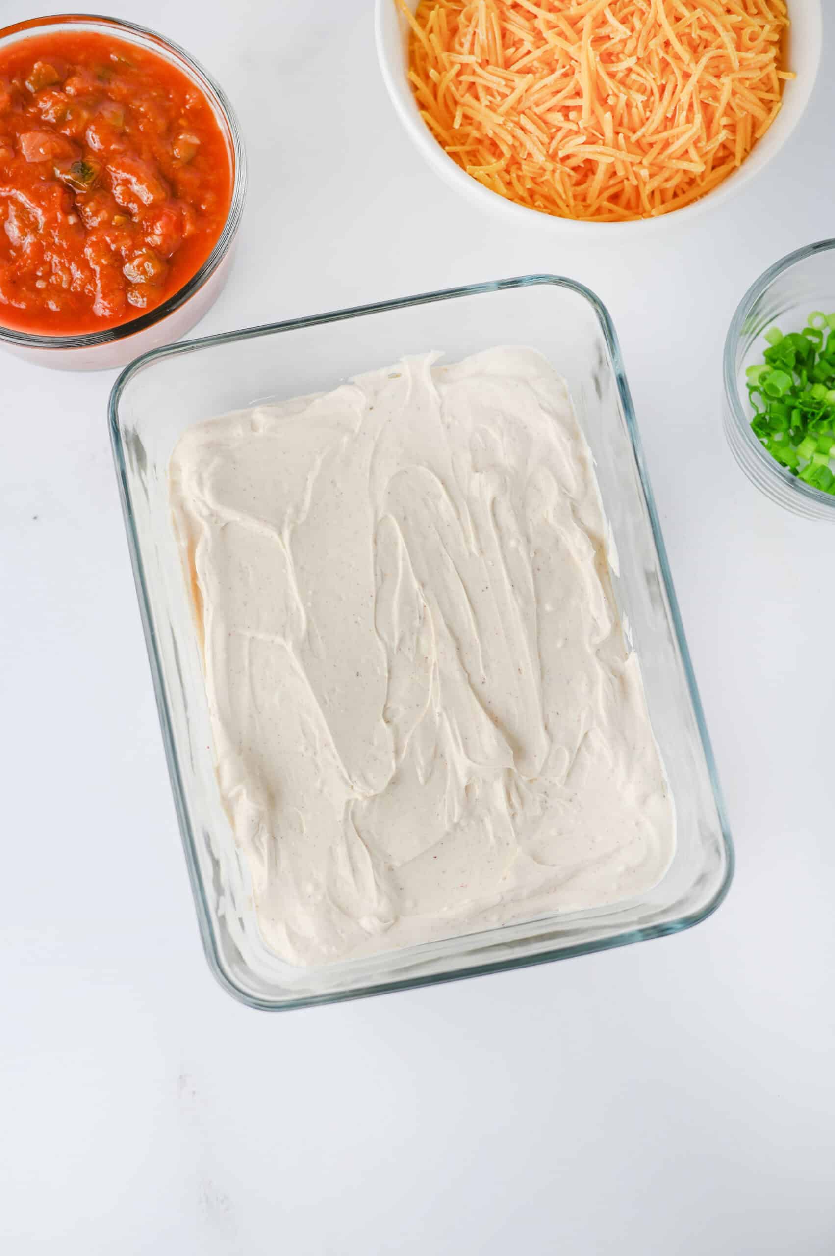 Creamy Greek yogurt and cream cheese mixture spread in a serving dish.
