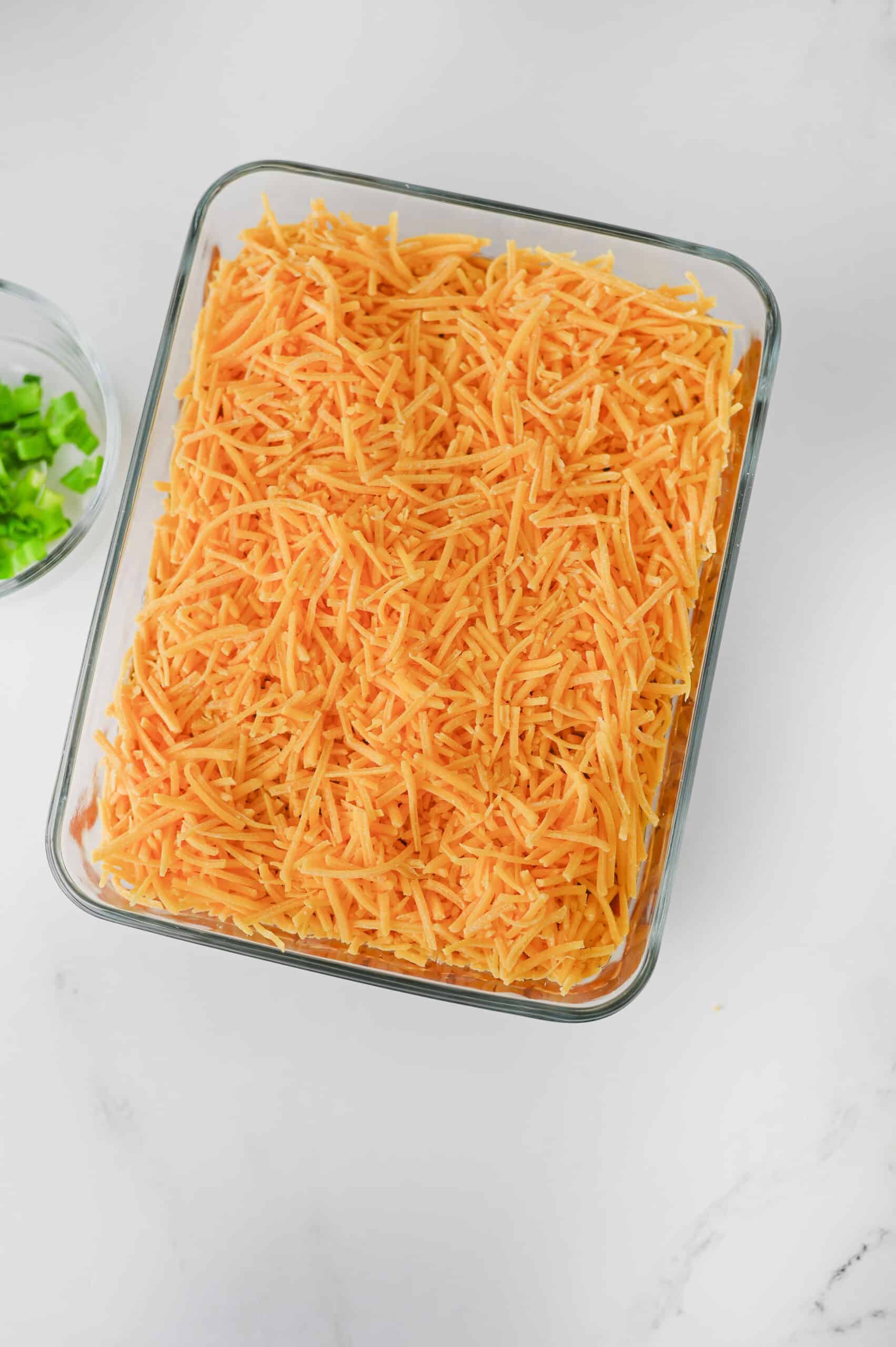 Shredded cheddar cheese layered over the salsa.