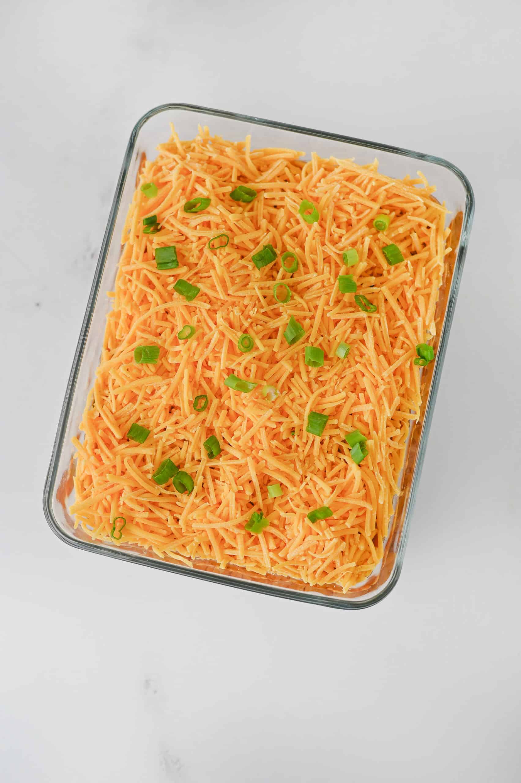Nacho dip topped with cheddar cheese and sliced green onions.