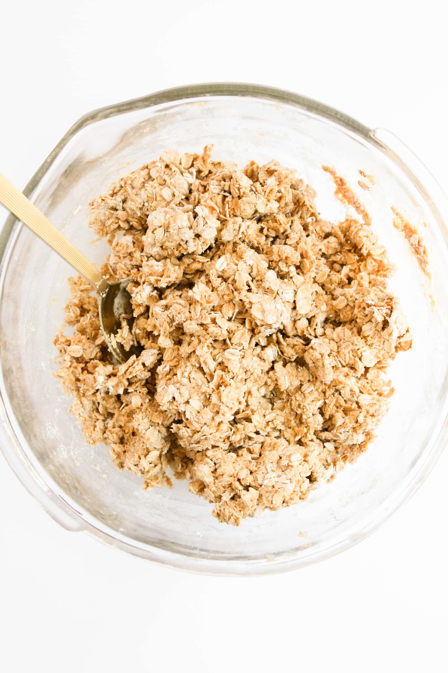 Peanut butter oat protein bite mixture stirred together in a glass bowl.