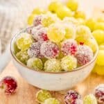 A bowl of sparkling sugar coated red and green grapes.