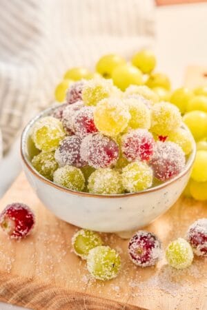 A bowl of sparkling sugar coated red and green grapes.