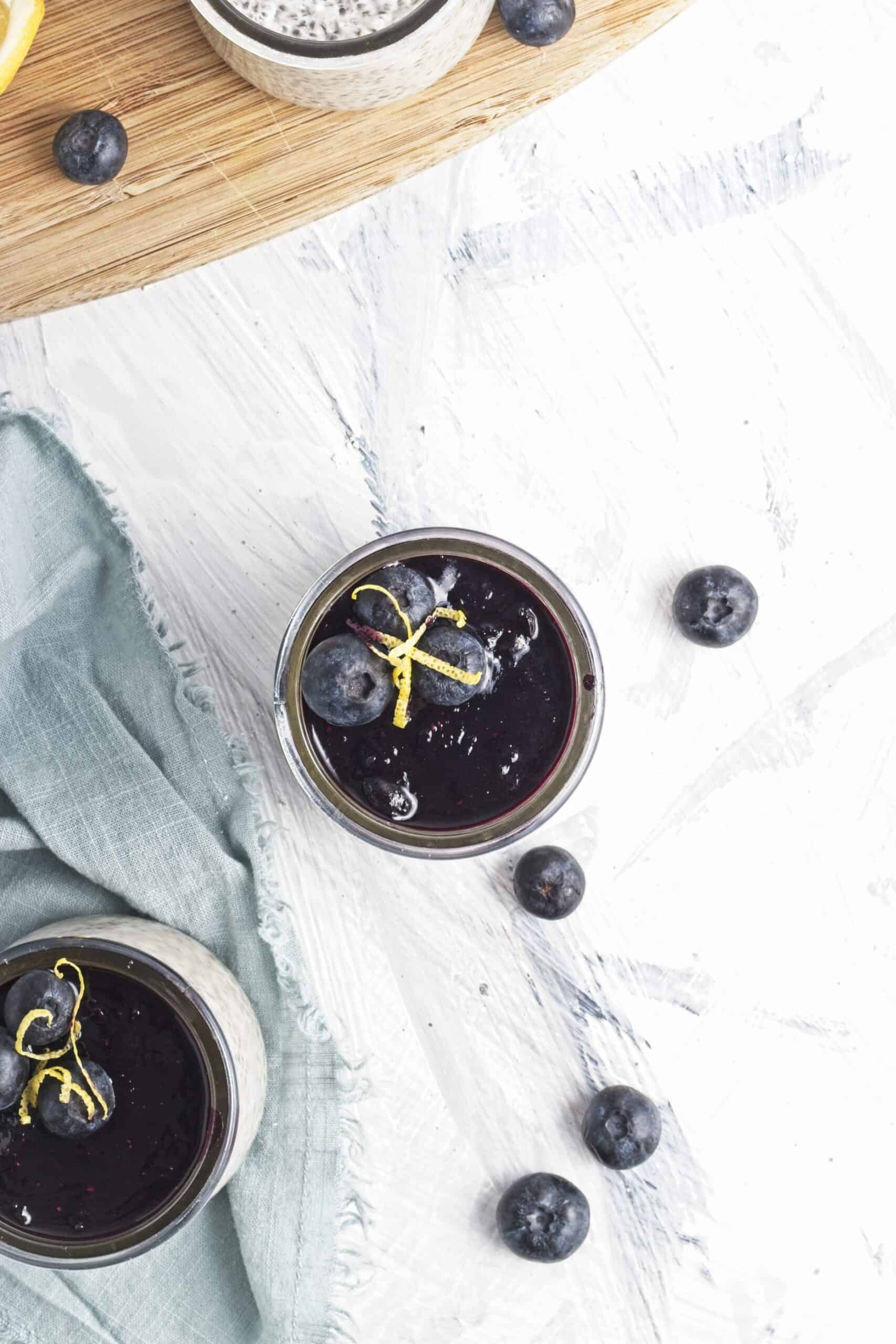 Chia pudding cups topped with blueberry compote, fresh blueberries, and lemon zest.