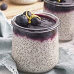 Close-up of creamy lemon chia pudding topped with blueberry compote, fresh blueberries, and lemon zest.