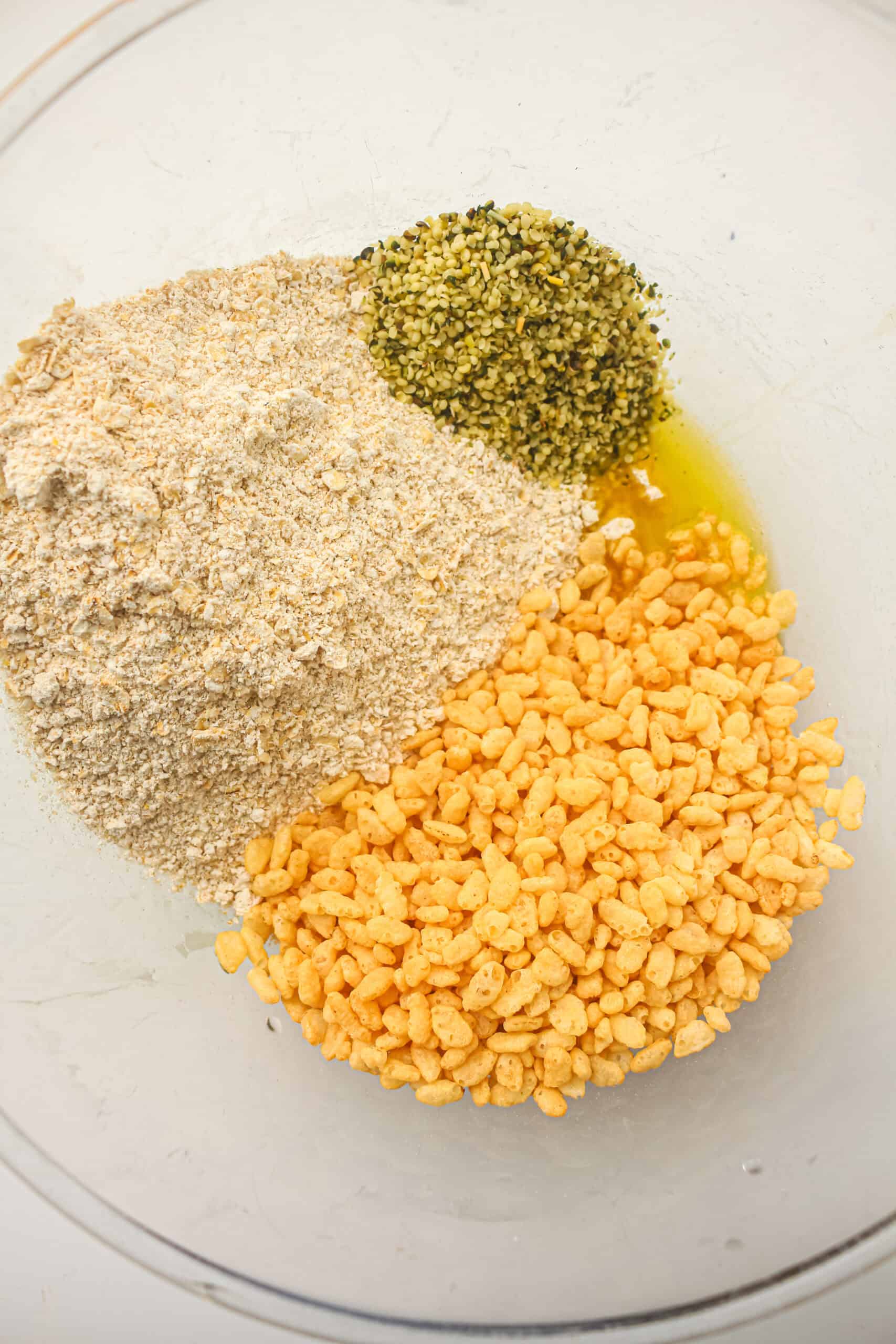 Oat flour, hemp seeds, and rice crisps added to the wet mixture.