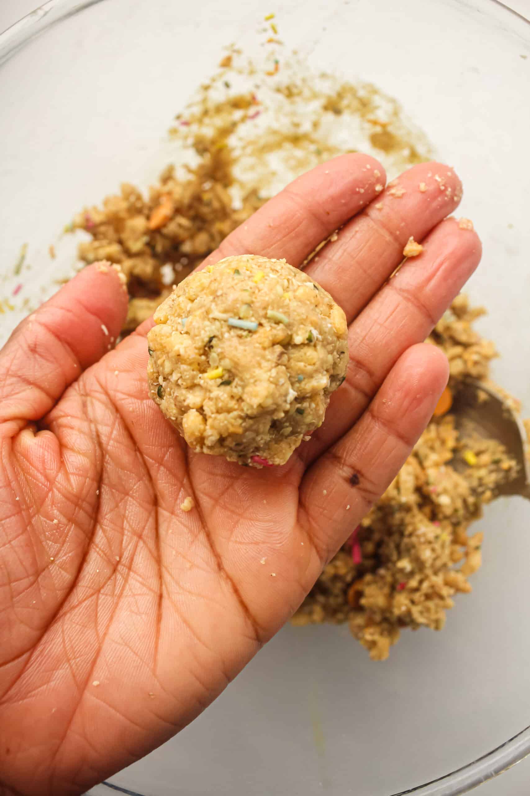 Energy ball mixture being rolled into a ball by hand.