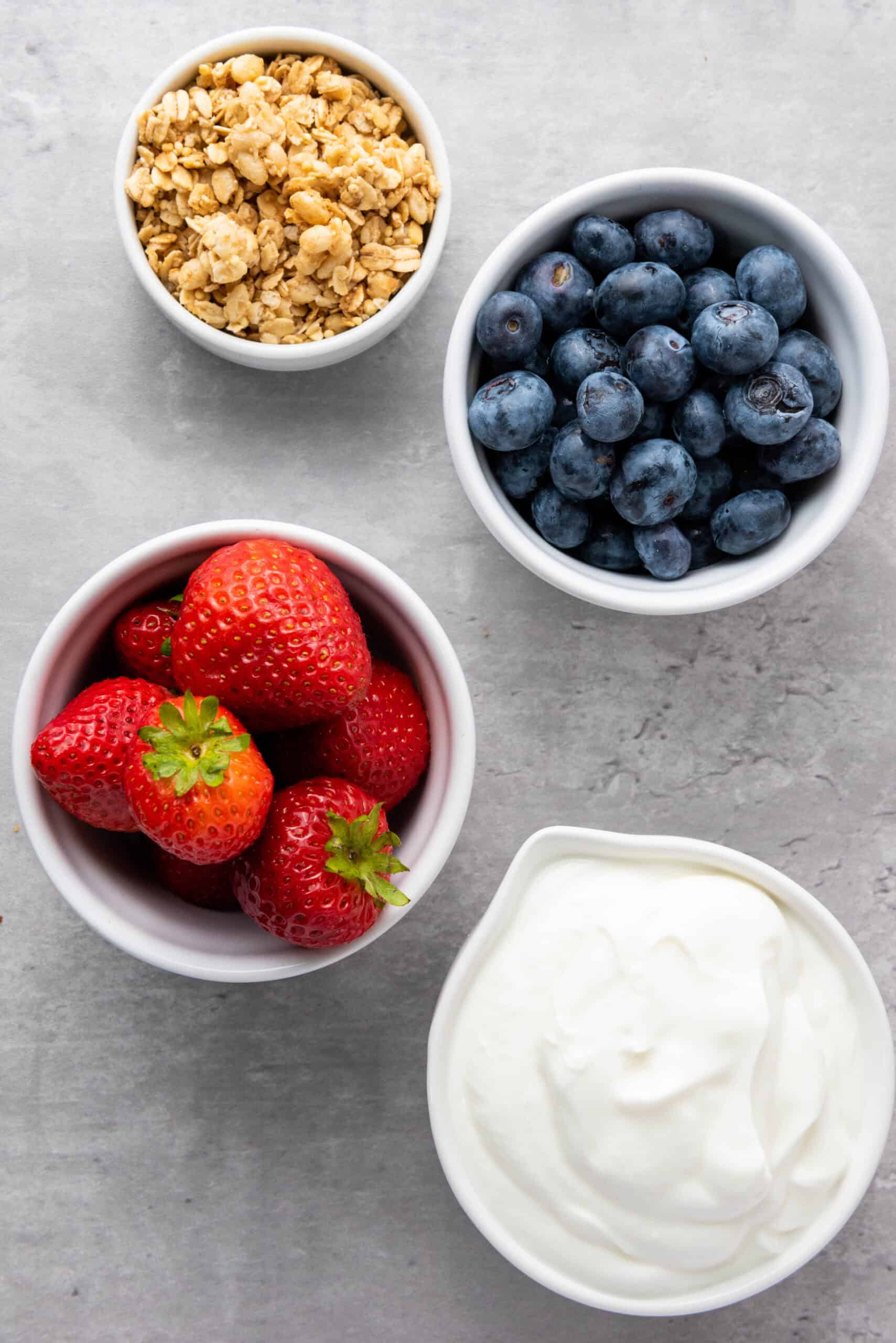 Vanilla Greek yogurt, blueberries, strawberries, and granola for frozen yogurt bites.