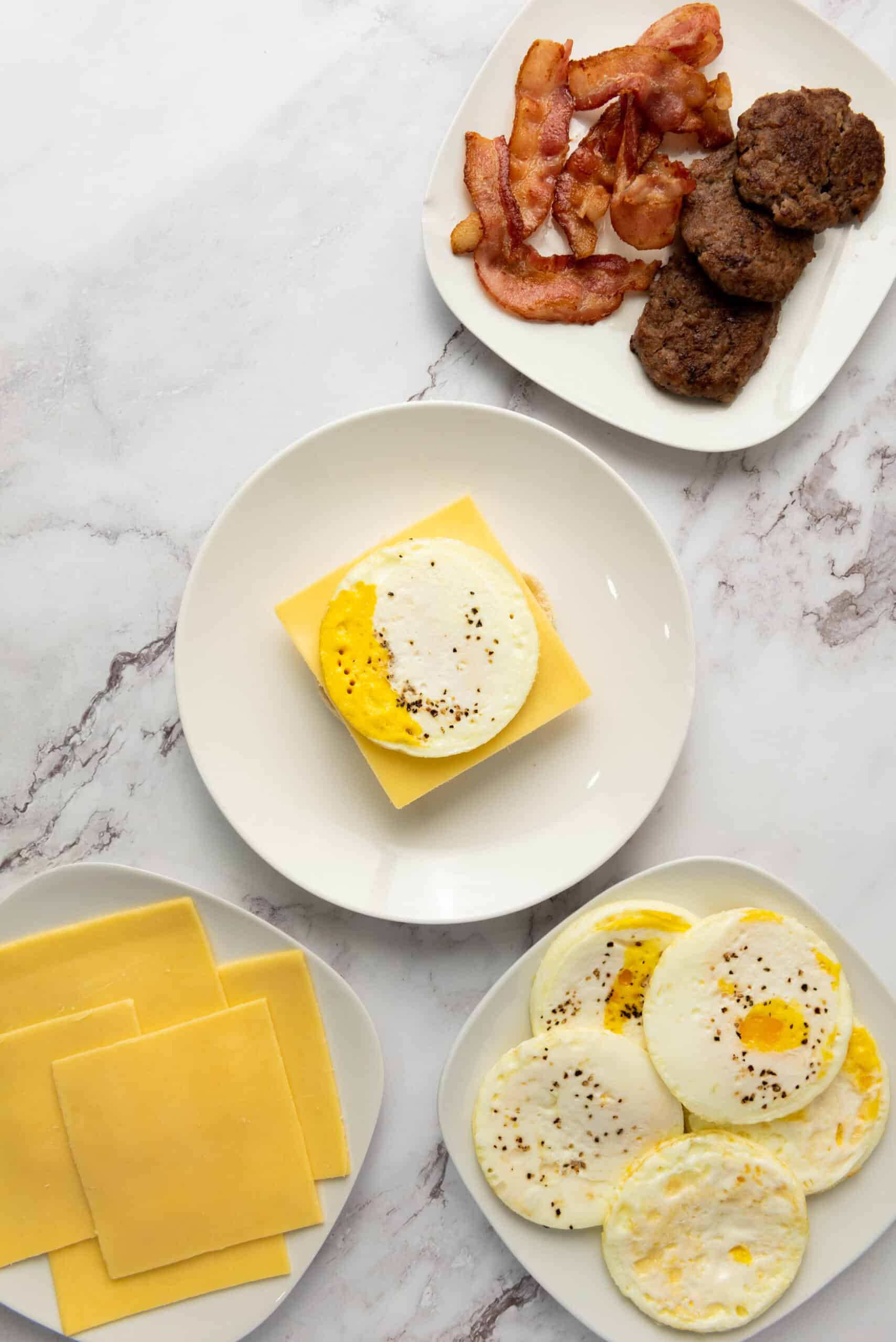 A cooked egg placed on top of cheese on an English muffin.