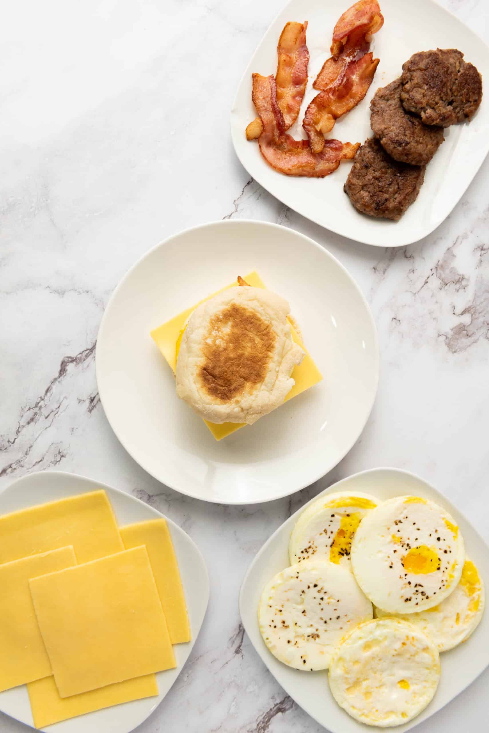A bacon, egg, and cheese breakfast sandwich closed with the top English muffin half.