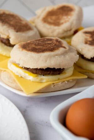 Freezer-friendly bacon and sausage breakfast sandwiches with egg and cheese on English muffins.