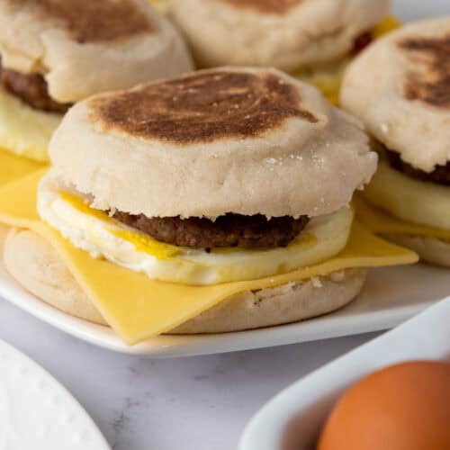 Freezer-friendly bacon and sausage breakfast sandwiches with egg and cheese on English muffins.