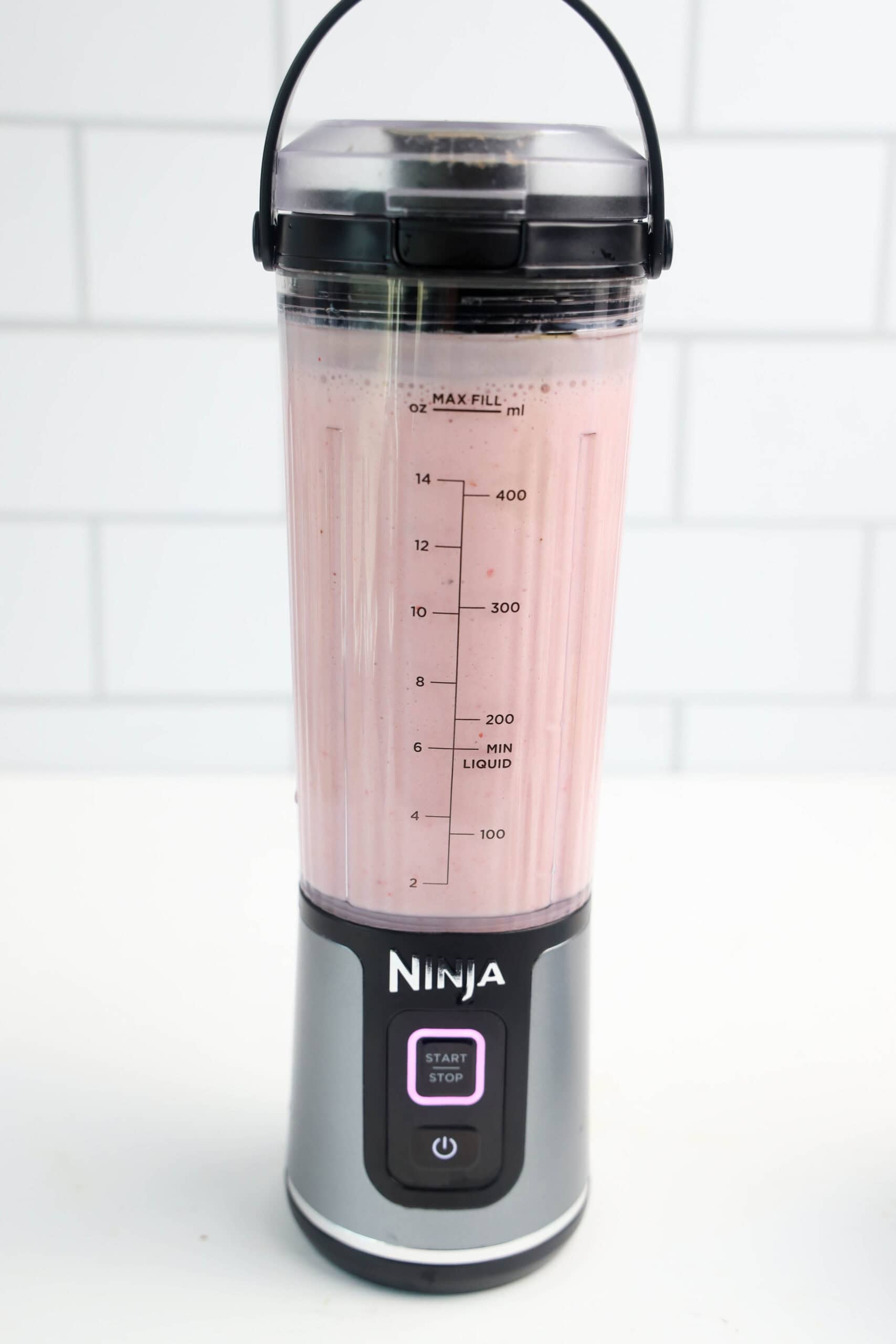 Smooth strawberry banana smoothie blended in a personal blender.