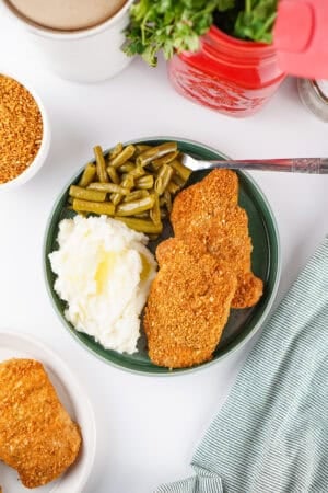 Homemade Shake and Bake pork chops served with mashed potatoes and green beans.