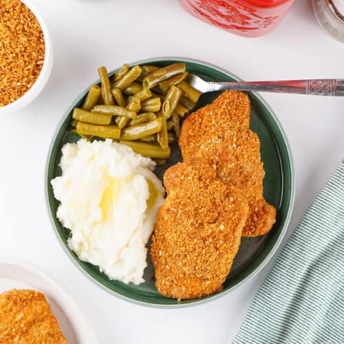 Homemade Shake and Bake pork chops served with mashed potatoes and green beans.