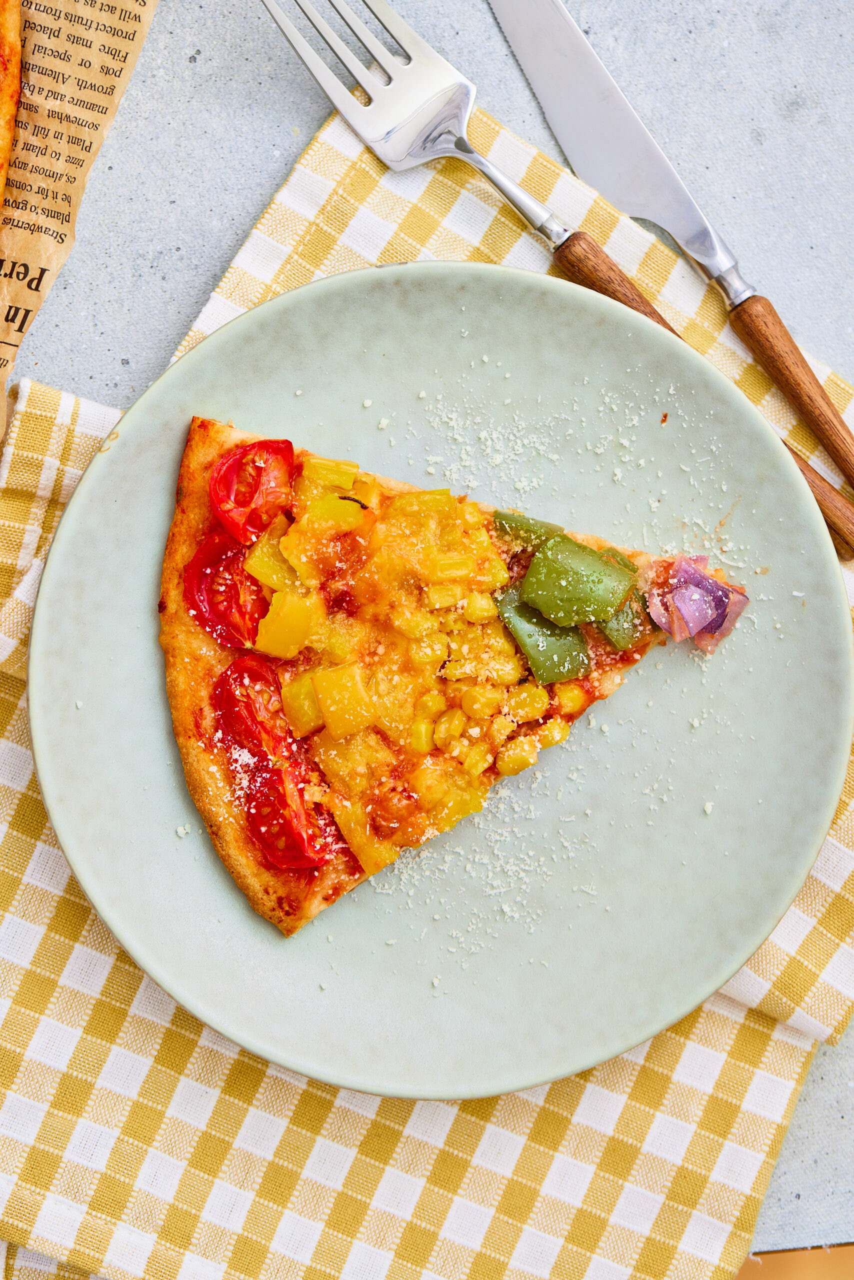 A slice of rainbow wheel veggie pizza served on a plate.