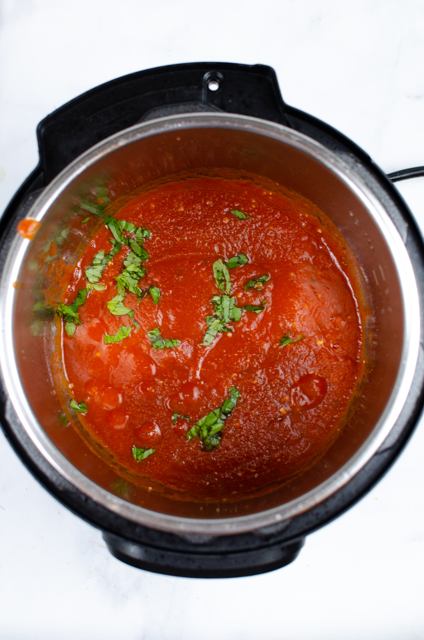 Marinara sauce with garlic and fresh basil in an Instant Pot.