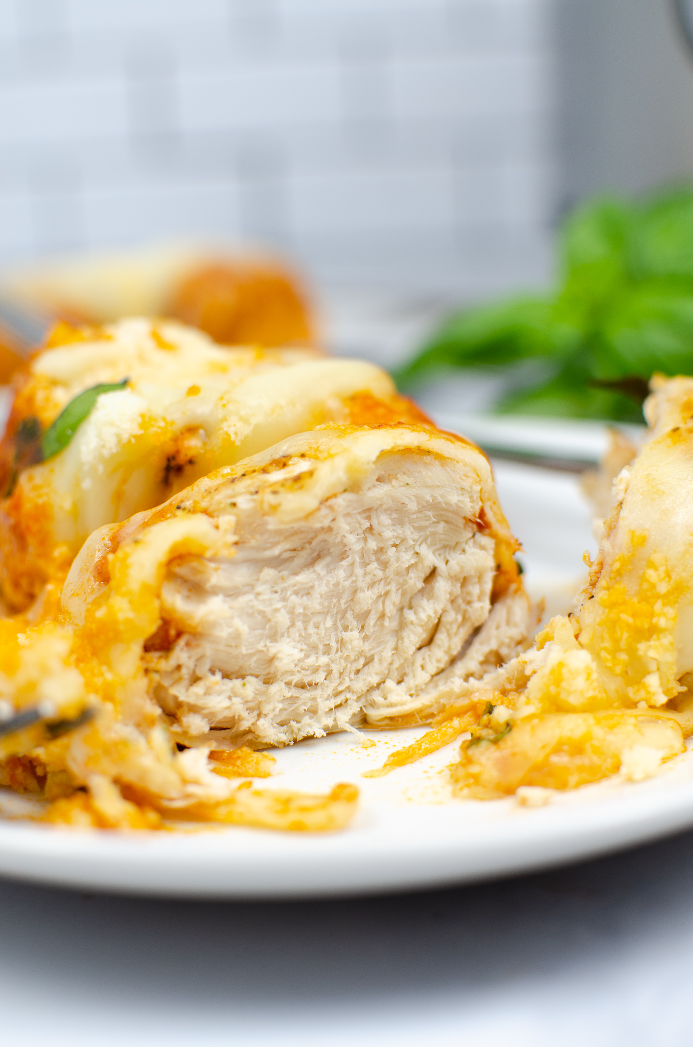 Sliced Instant Pot chicken Parmesan showing the juicy chicken breast and melted cheese.