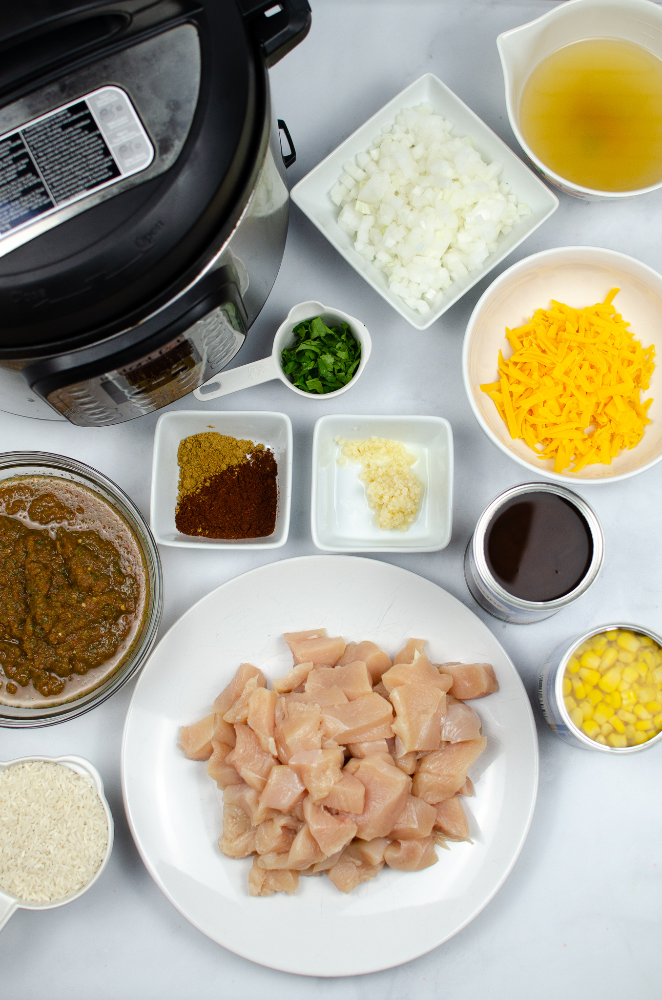 Chicken, rice, black beans, corn, salsa, broth, onion, garlic, spices, cheddar, cilantro, and an Instant Pot.