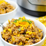 Instant Pot chicken burrito bowl with rice, chicken, black beans, corn, cheddar, and cilantro.