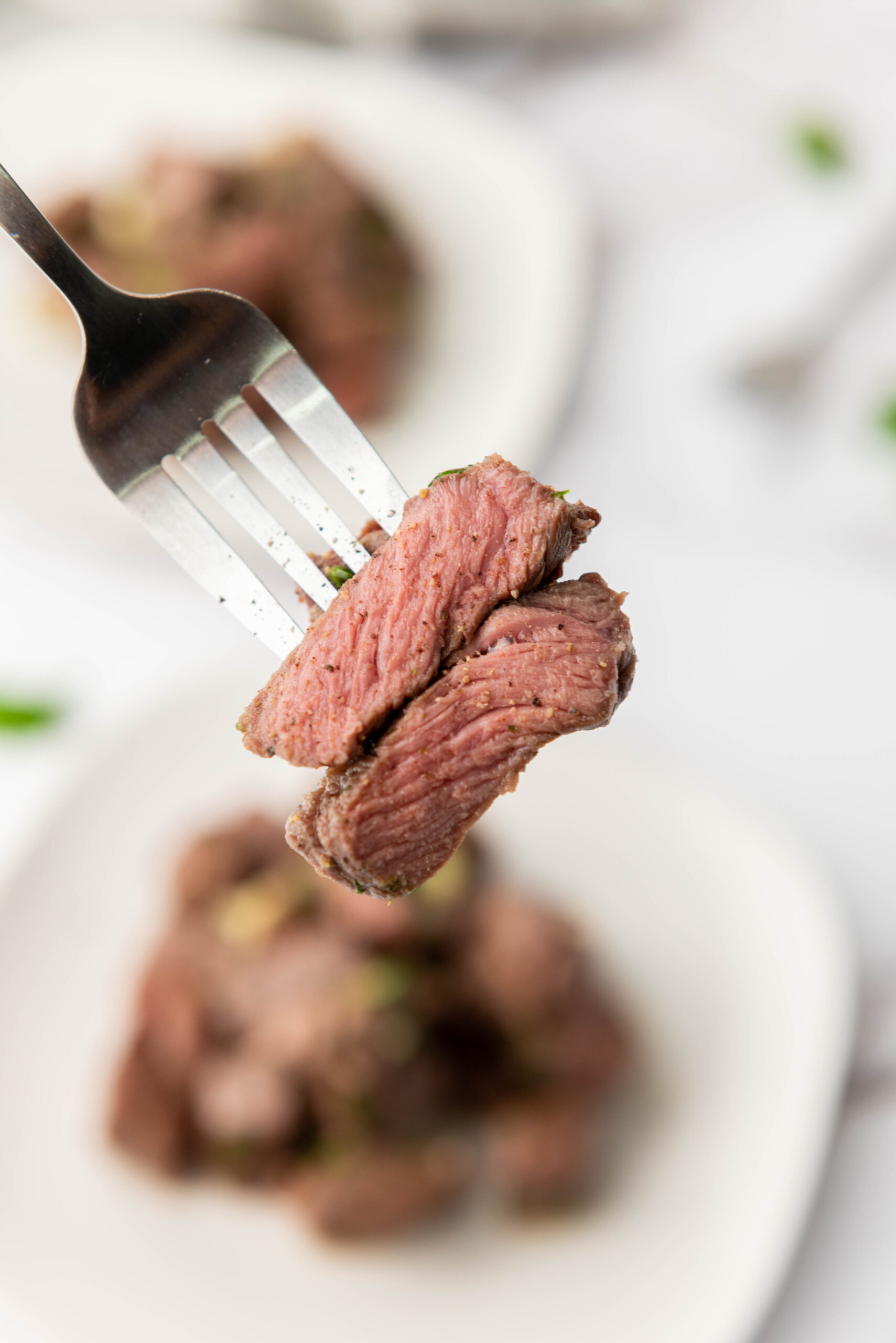 Juicy garlic butter steak bites shown on a fork.