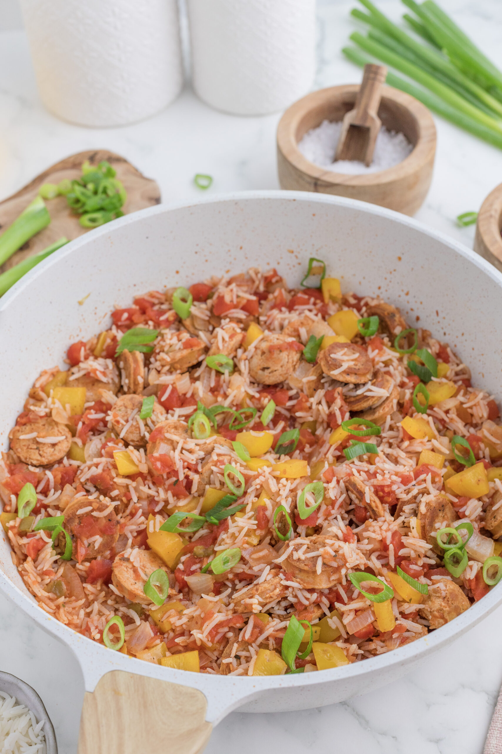 Finished Cajun sausage and rice casserole garnished with green onions in a skillet.