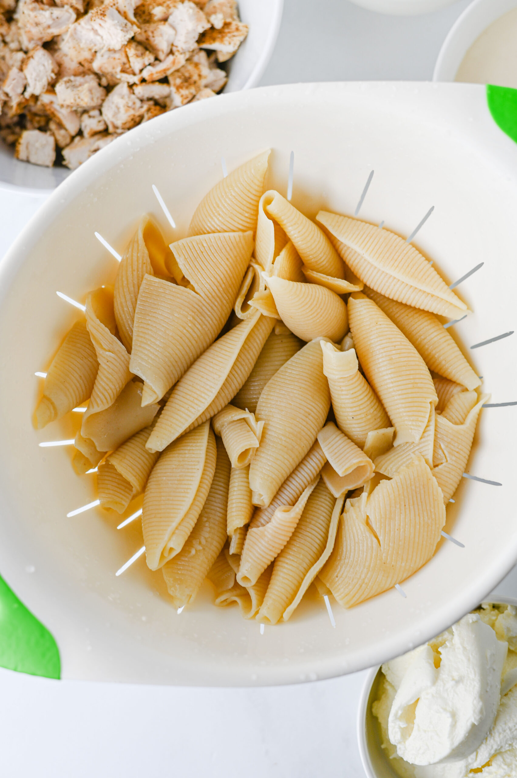 Cooked jumbo pasta shells draining in a colander.