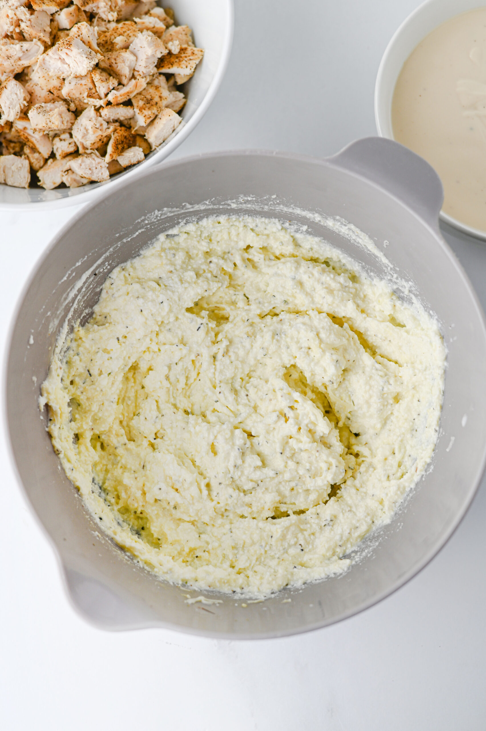 Ricotta, parmesan, egg, mozzarella, and seasonings mixed in a bowl.