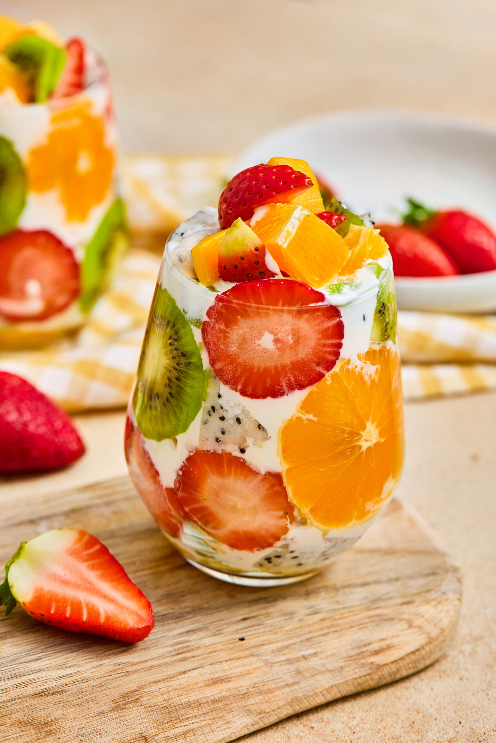 A tropical fruit parfait cup layered with Greek yogurt, mango, strawberries, kiwi, orange, and dragon fruit.