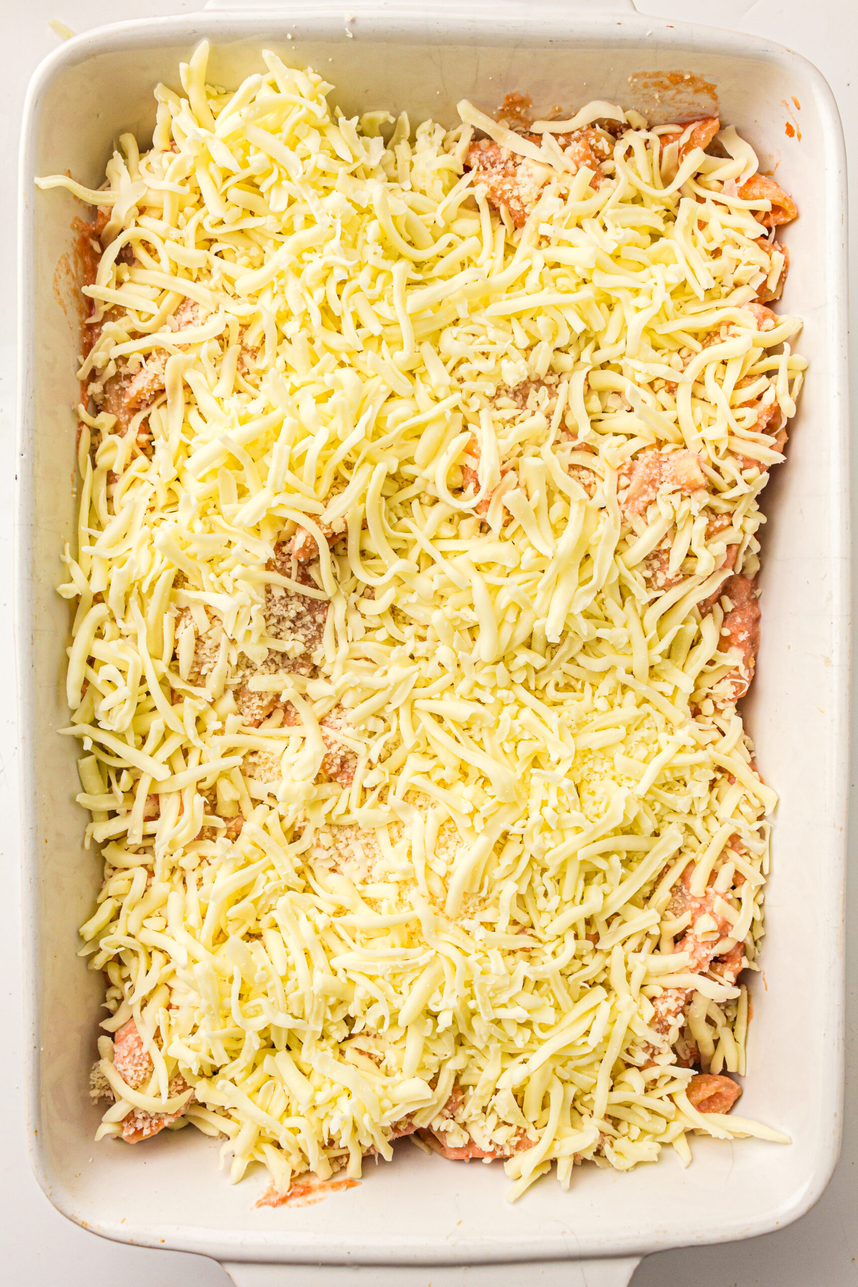 Shredded mozzarella and parmesan spread over the baked ziti.