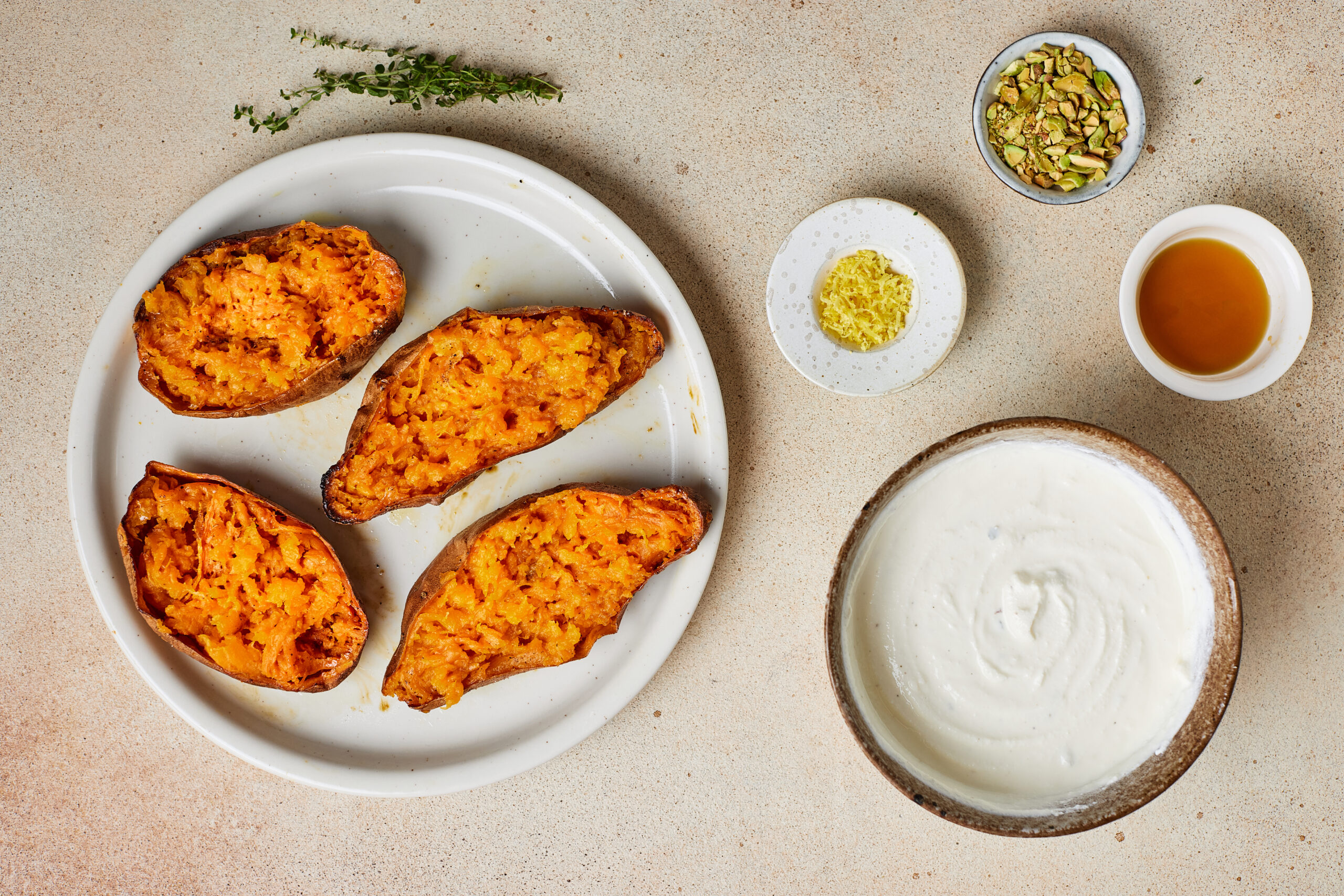 Roasted sweet potato halves with the tender flesh fluffed with a fork.
