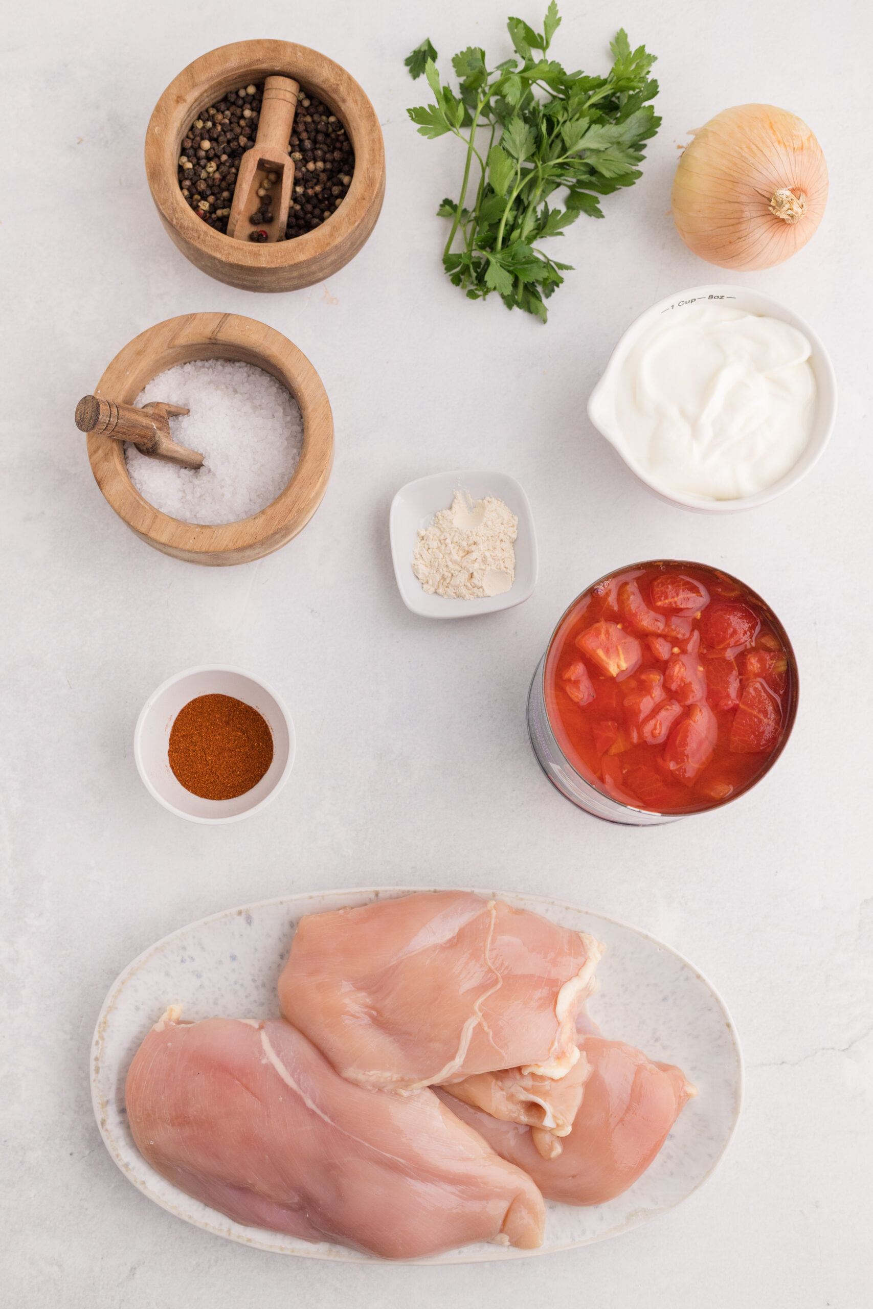 Chicken breasts, onion, diced tomatoes, sour cream, paprika, garlic powder, parsley, salt, and pepper.
