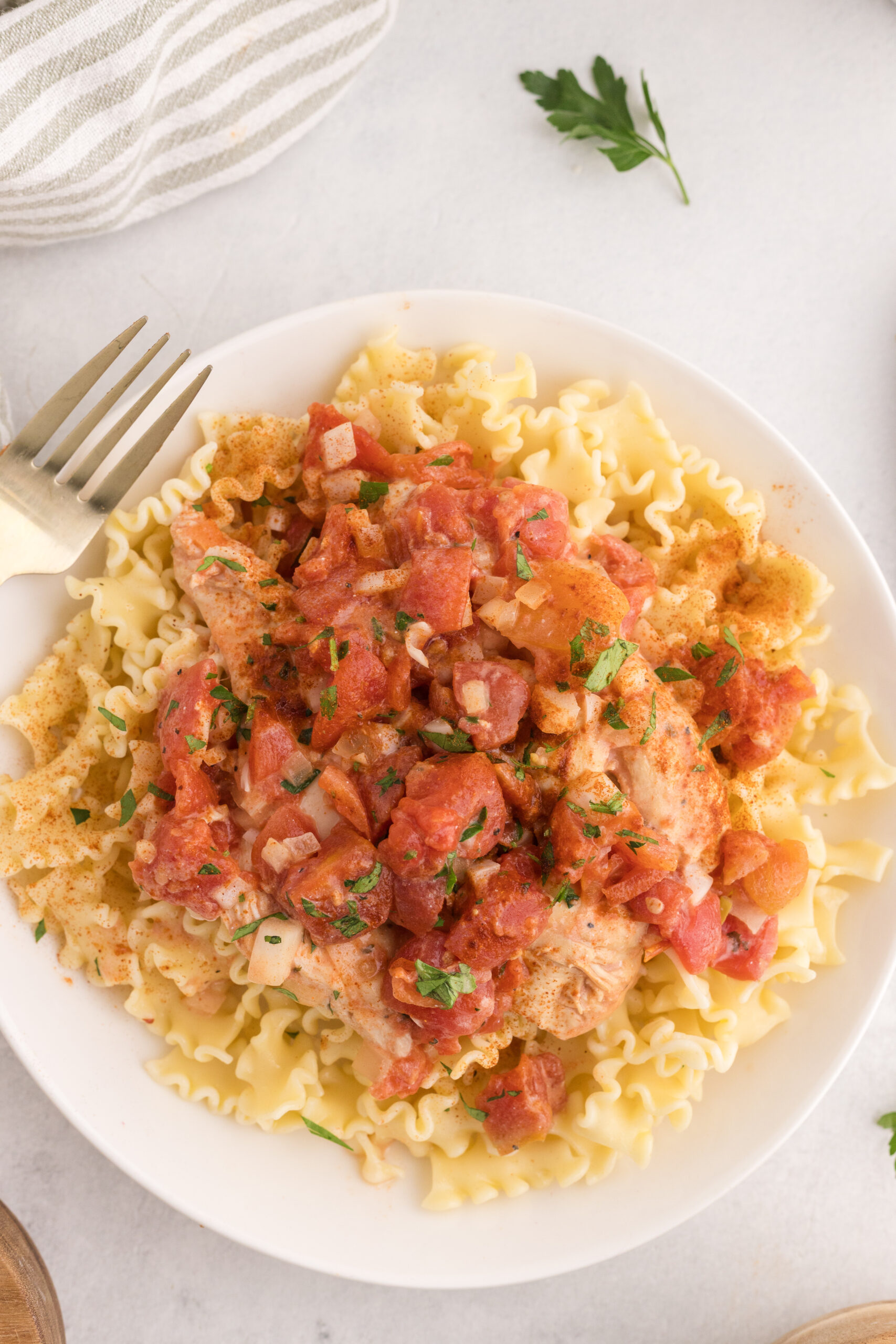 Slow cooker chicken paprikash served over egg noodles with parsley.