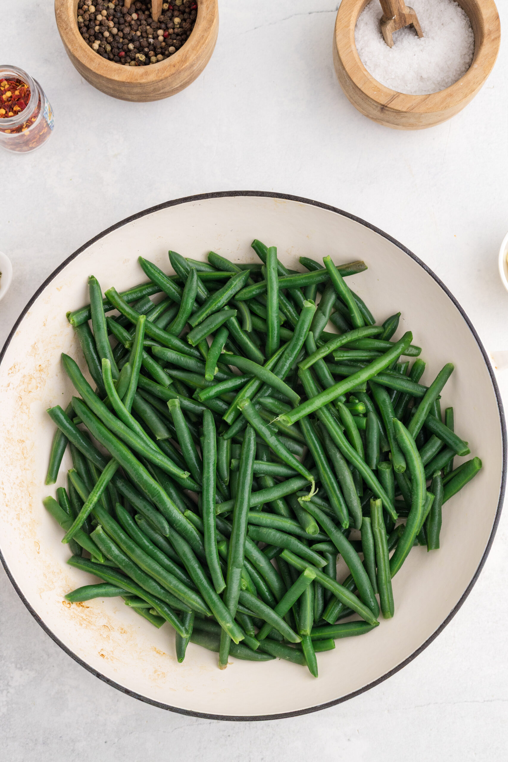 Green beans steaming in a large skillet until tender.