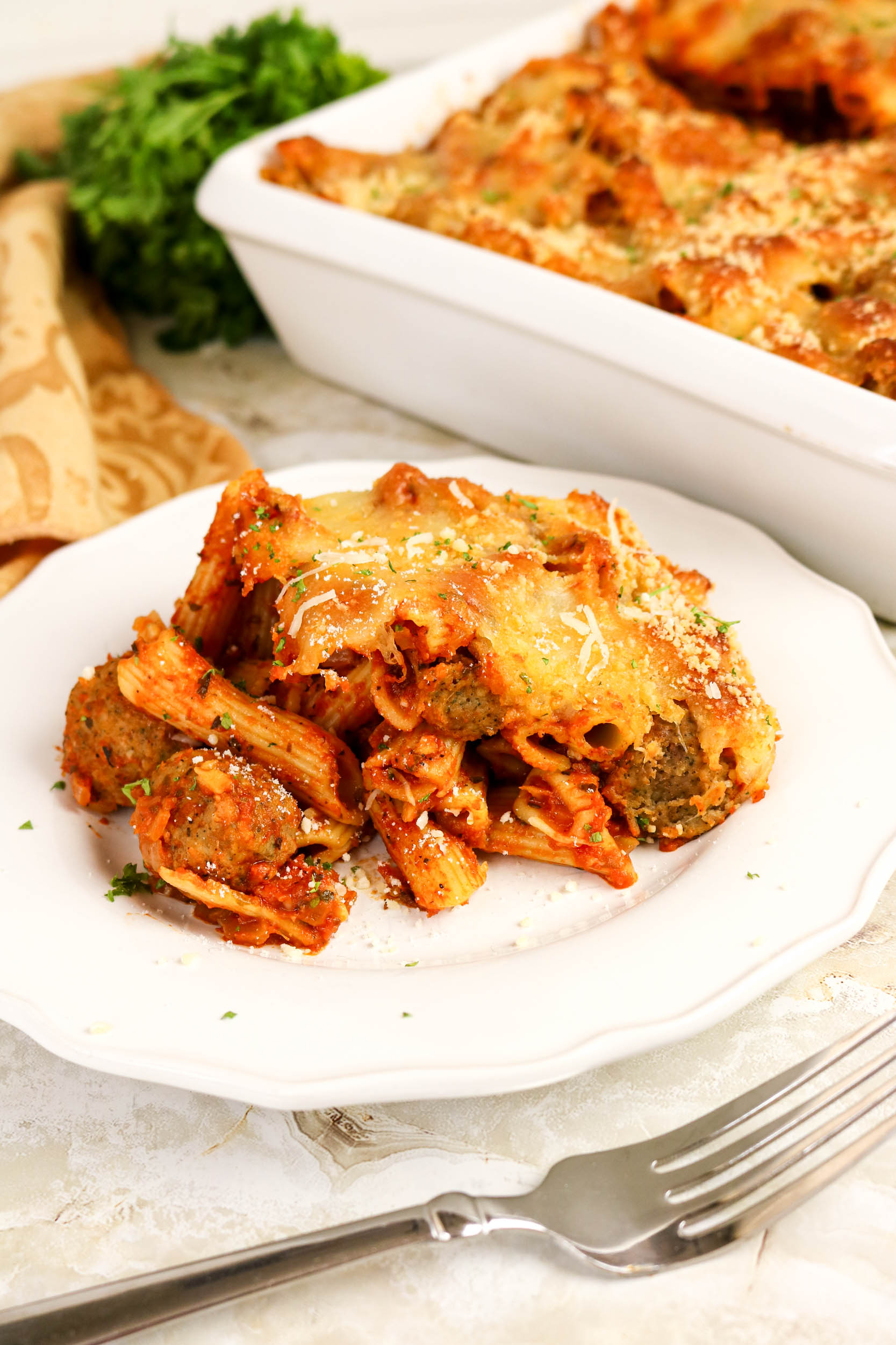 Penne and meatball casserole served on a white plate.