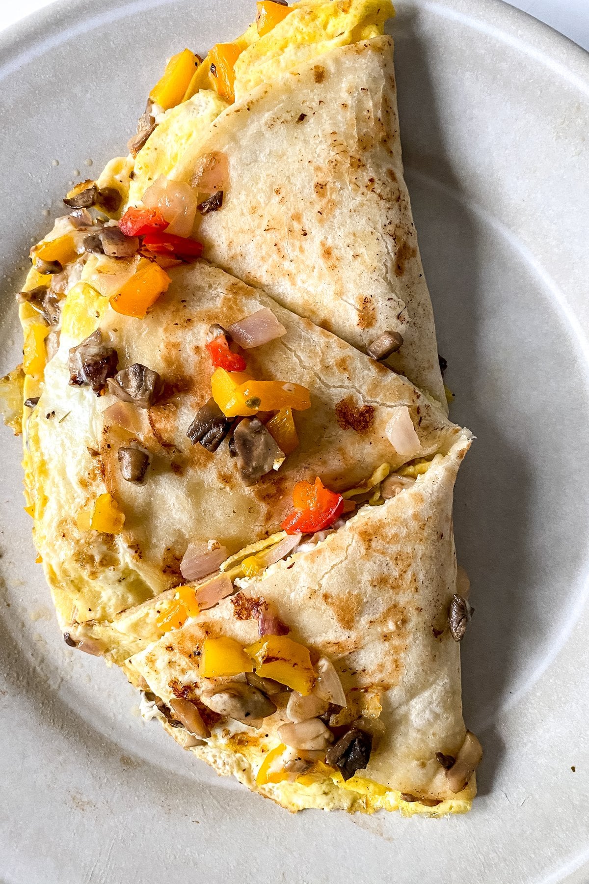 breakfast quesadilla cut into wedges on a plate