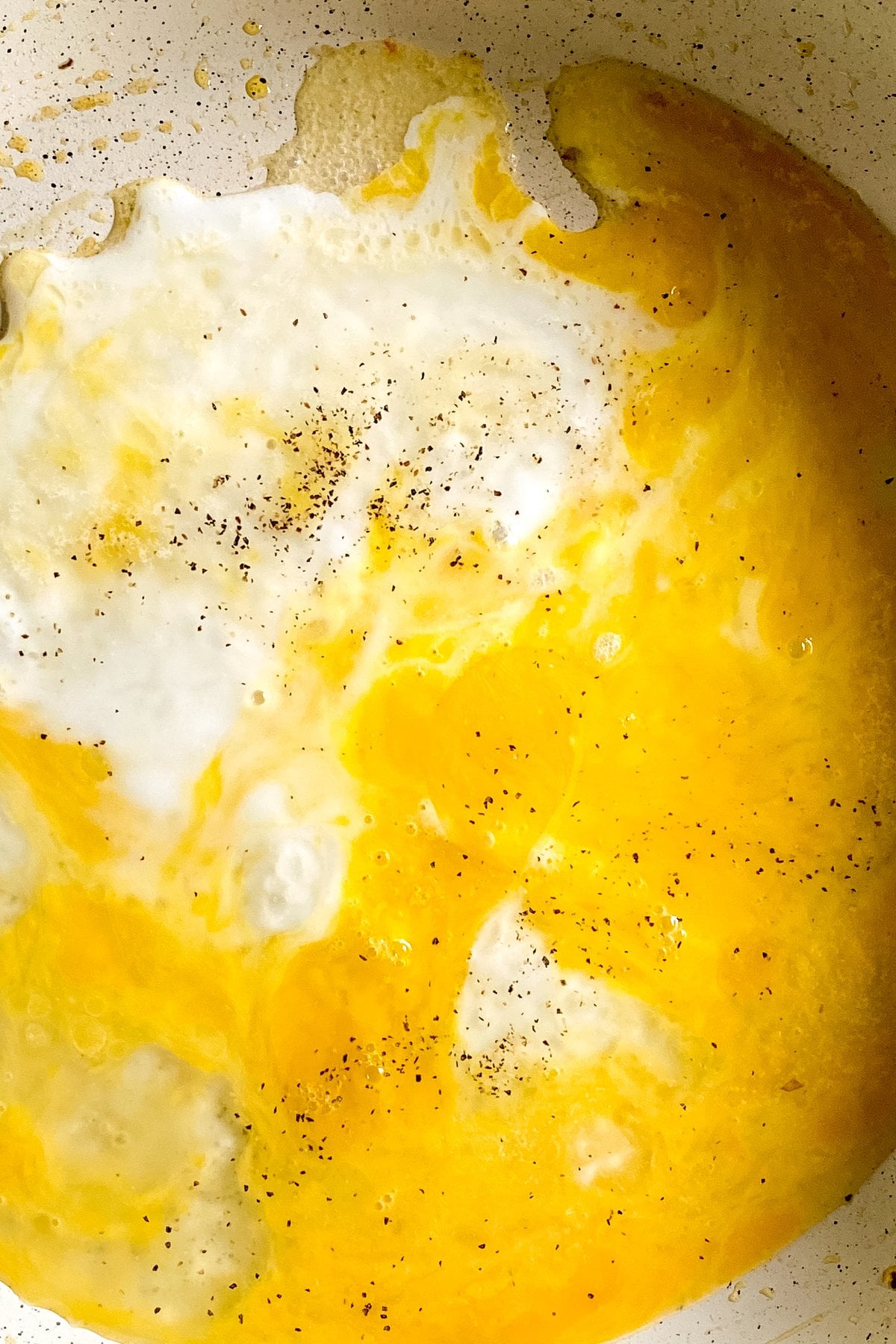 whisked eggs spread in a skillet for a tortilla egg breakfast