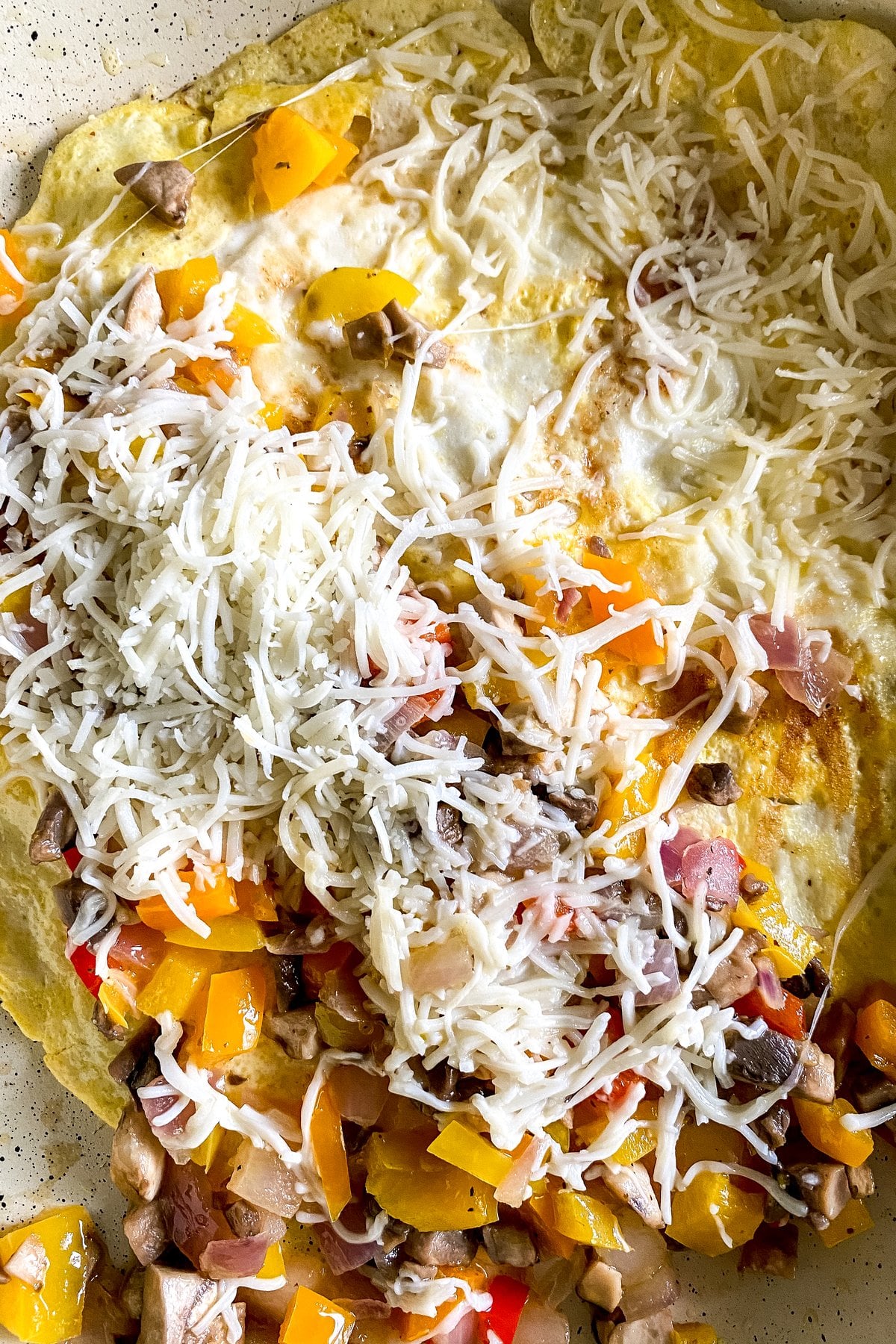 veggies and cheese on half of the breakfast quesadilla